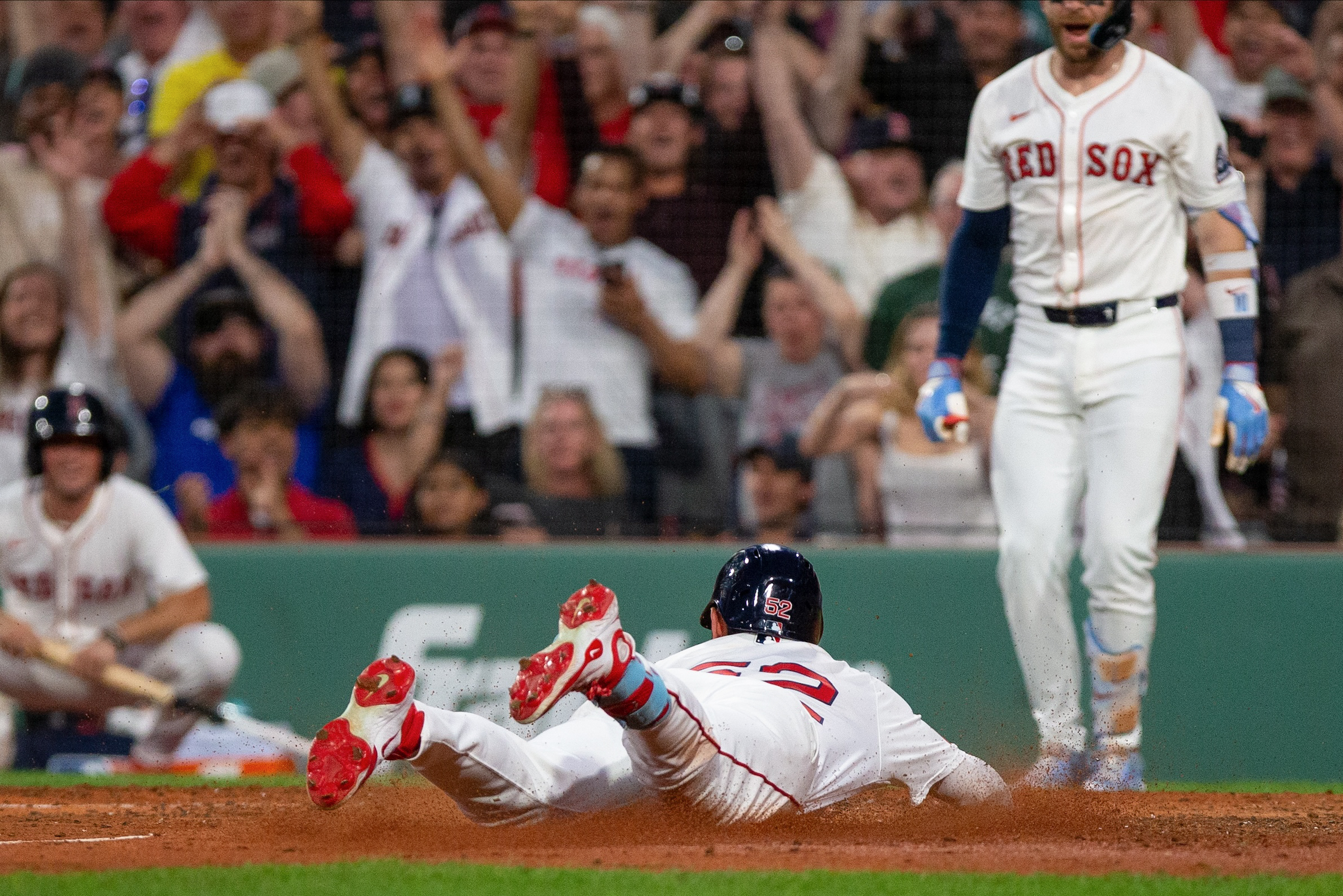 Wilyer Abreu #52 of the Boston Red Sox dives into home on an inside-the-park home run in the fifth inning during the game between the Cincinnati Reds and the Boston Red Sox at Fenway Park on Monday, June 30, 2025 in Boston, Massachusetts.