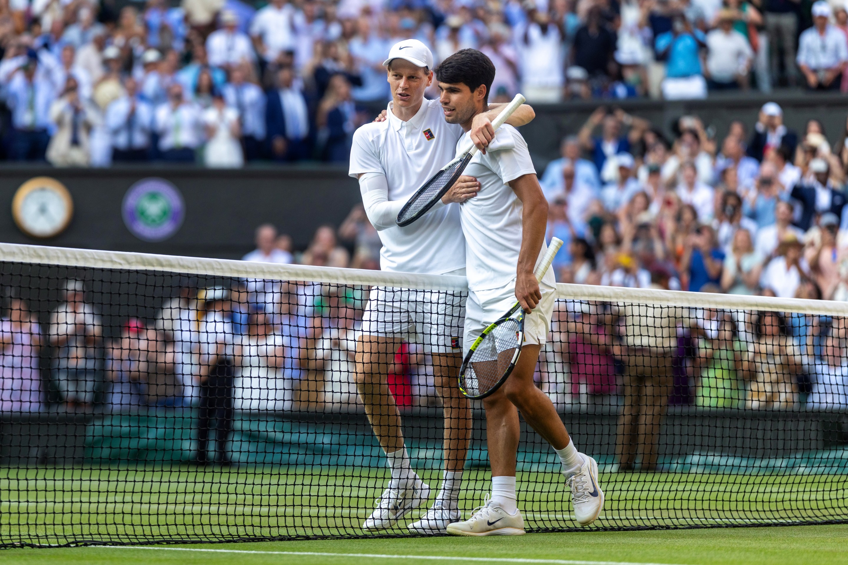 LONDON, ENGLAND - JULY 13: Winner Jannik Sinner of Italy and Carlos Alcaraz of Spain embrace at the net after the Gentlemen's Singles Final on Centre Court during the Wimbledon Lawn Tennis Championships at the All England Lawn Tennis and Croquet Club at Wimbledon on July 13th, 2025, in London, England. (Photo by Tim Clayton/Getty Images)