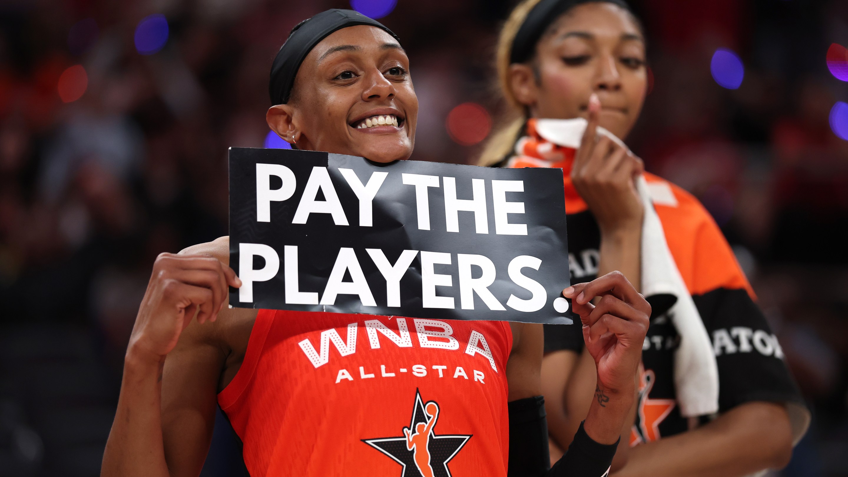 Brittney Sykes #15 of the Washington Mystics holds a "Pay the Players" sign following the 2025 AT&amp;T WNBA All-Star Game at Gainbridge Fieldhouse on July 19, 2025 in Indianapolis, Indiana.