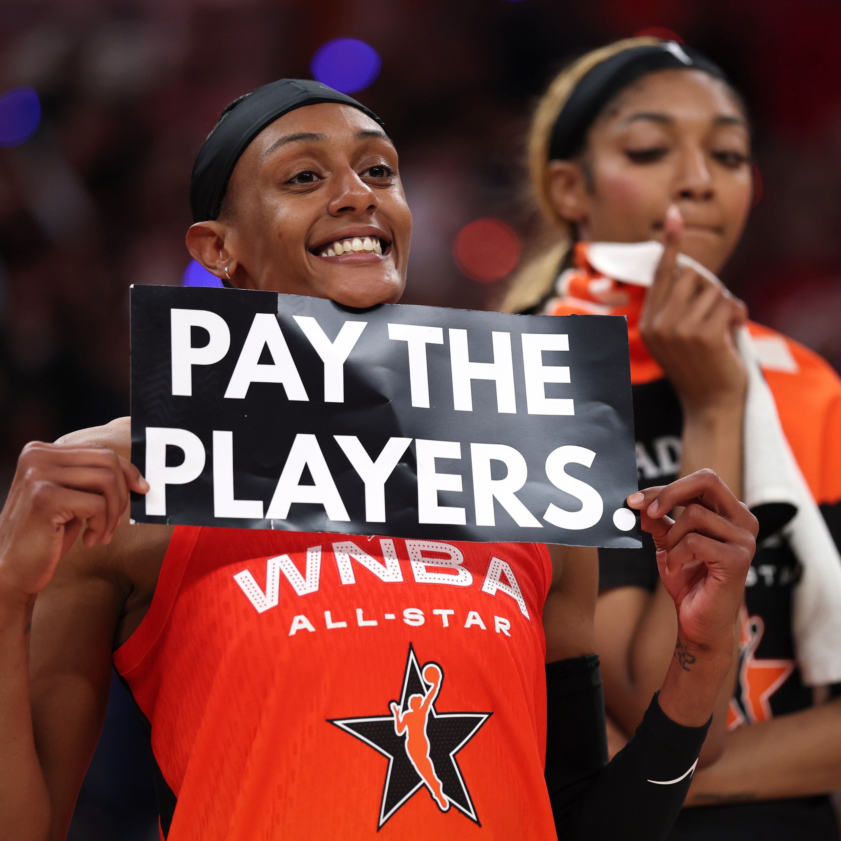 Brittney Sykes #15 of the Washington Mystics holds a "Pay the Players" sign following the 2025 AT&amp;T WNBA All-Star Game at Gainbridge Fieldhouse on July 19, 2025 in Indianapolis, Indiana.
