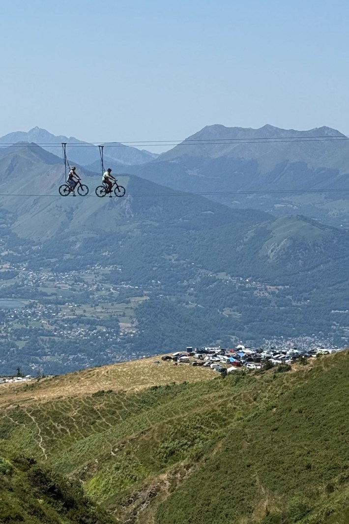 A pair of cyclists literally riding a tightrope hundreds of feet above the ground in the Pyrenees mountains.