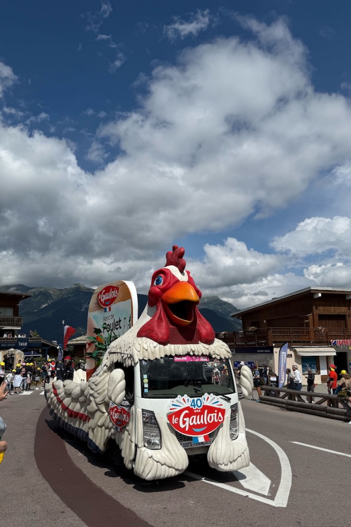 A Tour de France caravan float shaped like a chicken, advertising Le Gaulois.