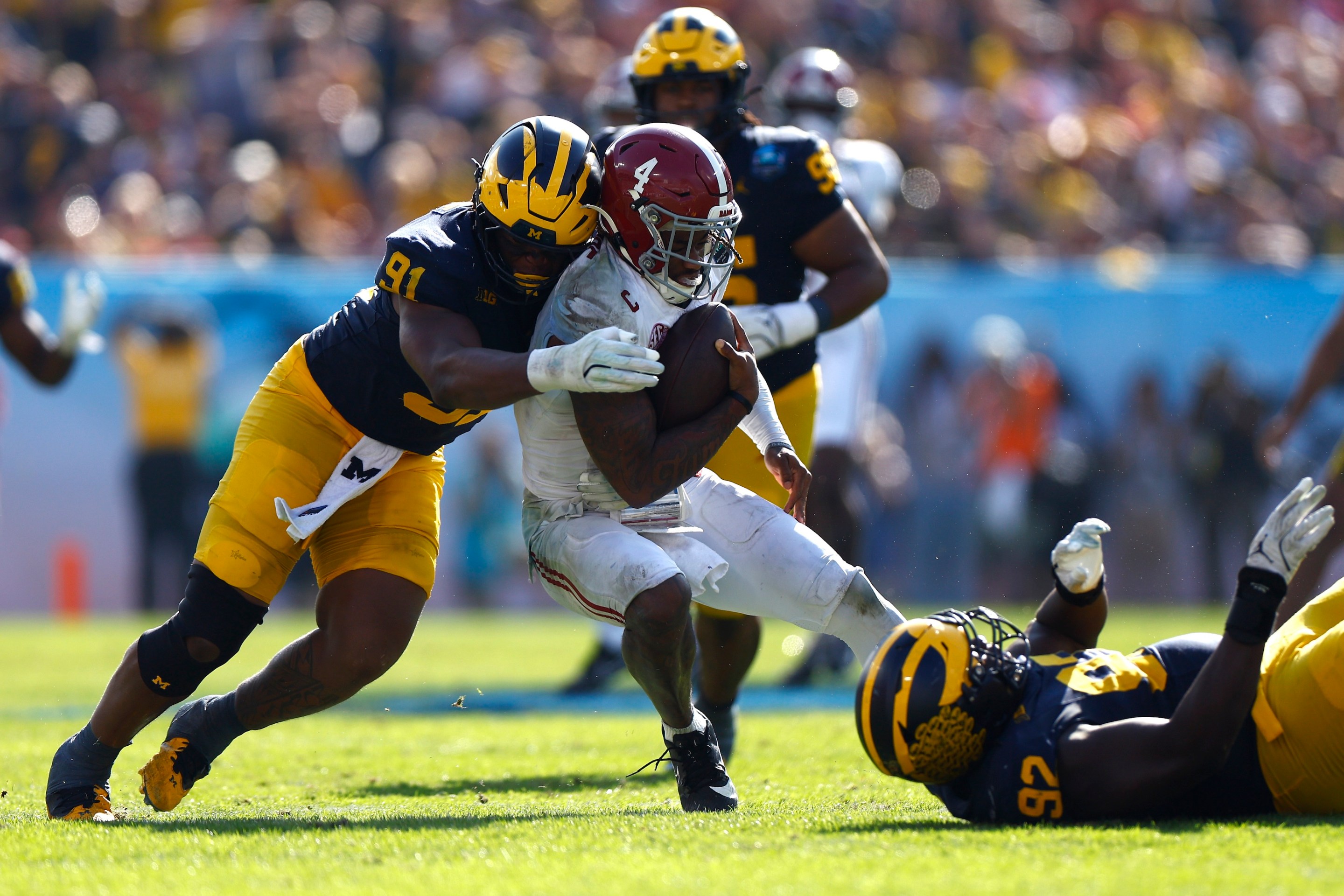 Jalen Milroe #4 of the Alabama Crimson Tide is sacked by Cameron Brandt #91 of the Michigan Wolverines during the third quarter in the 2024 ReliaQuest Bowl at Raymond James Stadium on December 31, 2024.