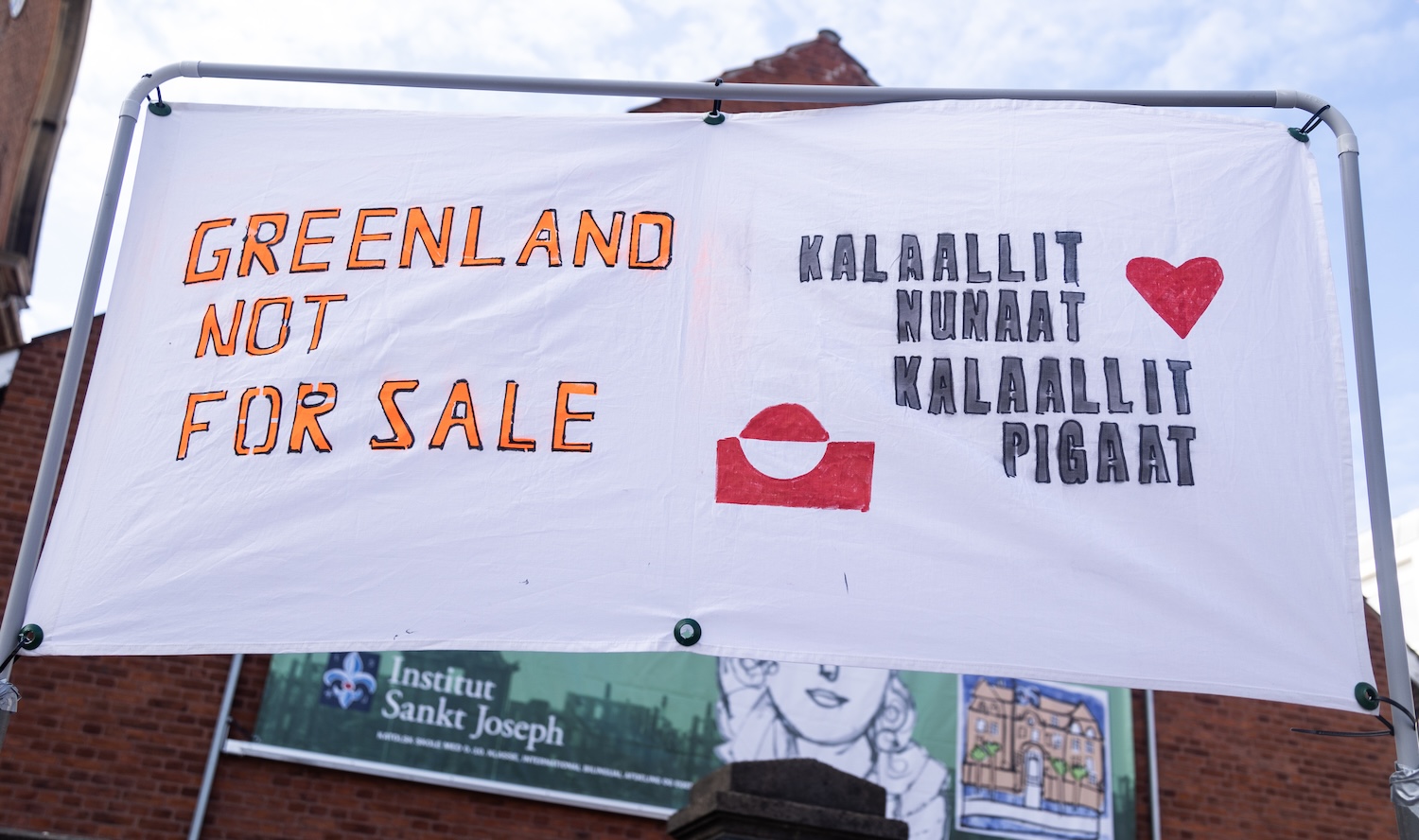 COPENHAGEN, DENMARK - 2025/04/06: A banner saying “Greenland not for sale” and “Kalaallit Nunaat Kalaallit Pigaat” translated to "Greenland belongs to the Greenlanders” seen during a demonstration against the Trump administration. Protesters gathered in front of the American Embassy in response to the Trump administration's repeated statements about wanting control over Greenland. These statements, which questioned Denmark’s sovereignty and emphasized Greenland’s strategic value, sparked outrage in both Greenland and Denmark. Greenlandic leaders and citizens strongly rejected any suggestion of being "for sale," stressing their right to self-determination and fears of losing their cultural identity. The situation has unified Greenland’s political parties and raised broader concerns about international law and Arctic geopolitics. (Photo by Kristian Tuxen Ladegaard Berg/SOPA Images/LightRocket via Getty Images)