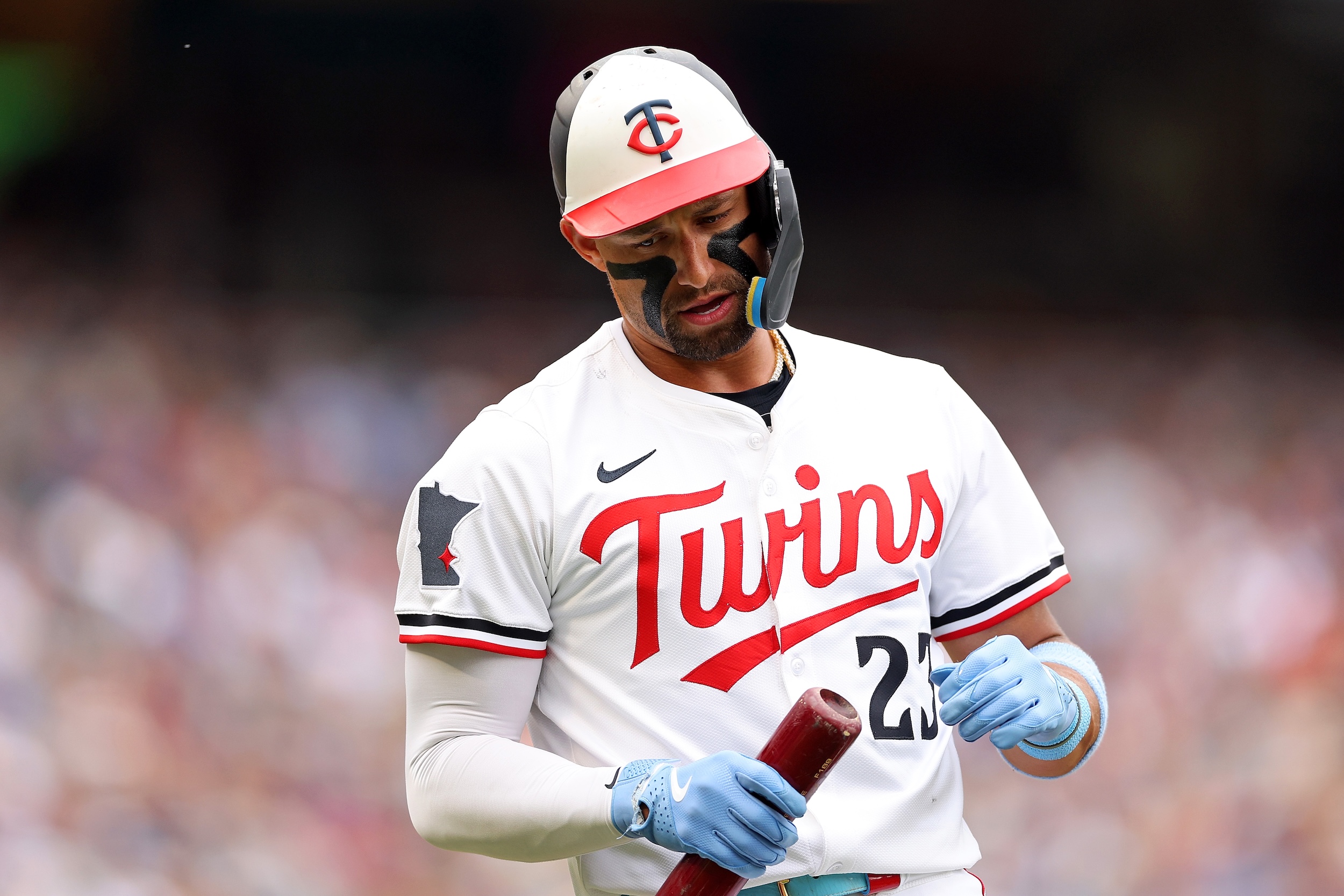 Royce Lewis looks at his bat.
