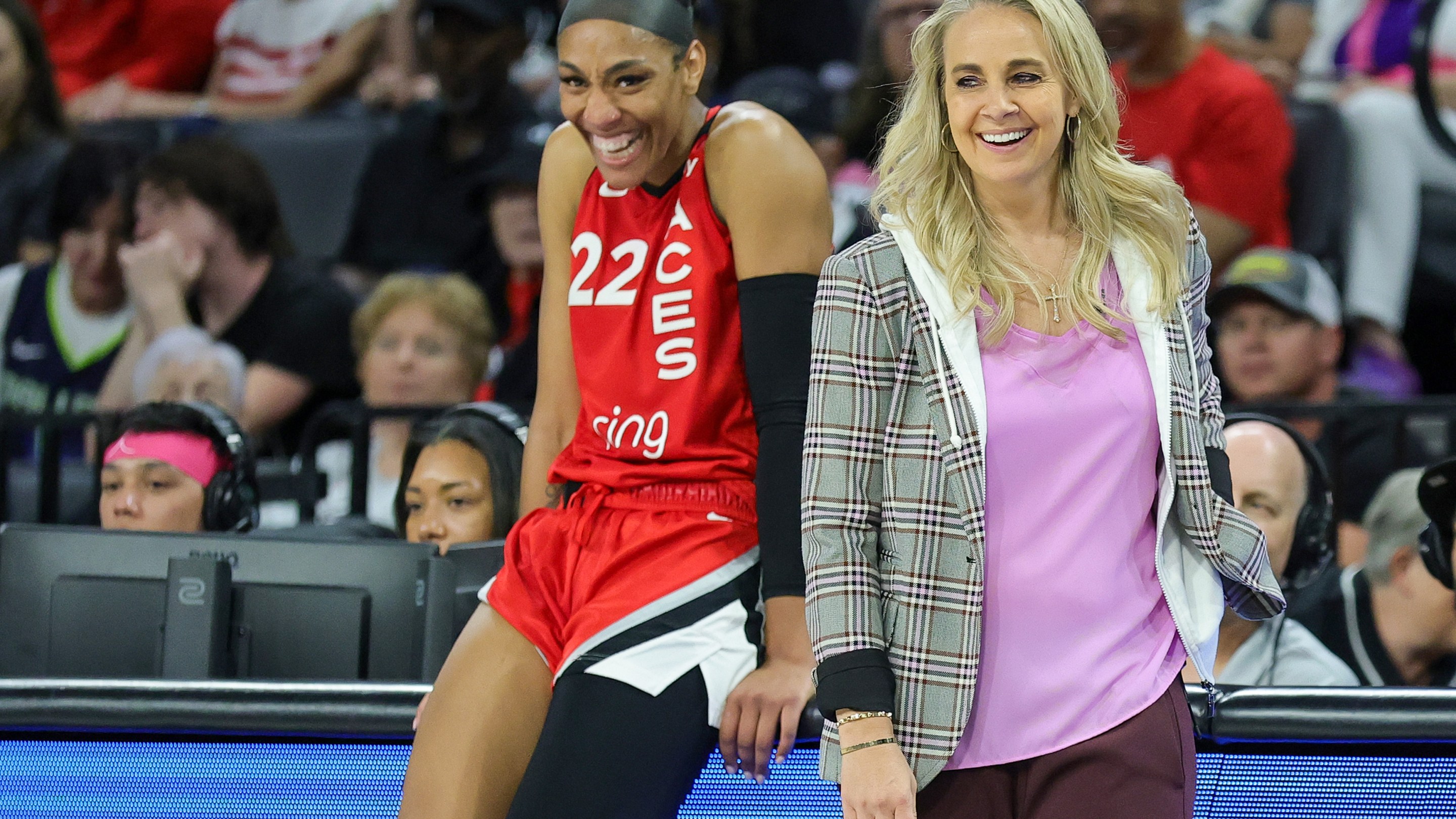 A'ja Wilson #22 and head coach Becky Hammon of the Las Vegas Aces laugh as Wilson waits to check in during the fourth quarter of a game against the Dallas Wings at Michelob ULTRA Arena on August 17, 2025 in Las Vegas, Nevada. The Aces defeated the Wings 106-87.