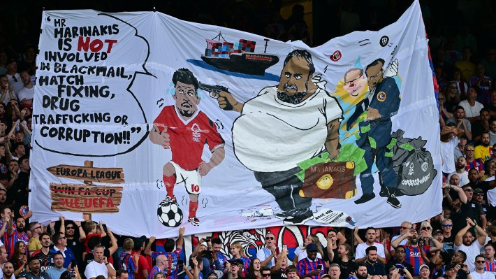 Crystal Palace fans hold a banner depicting Nottingham Forest's Greek co-owner Evangelos Marinakis and Nottingham Forest's English midfielder #10 Morgan Gibbs-White during the English Premier League football match between Crystal Palace and Nottingham Forest at Selhurst Park in south London on August 24, 2025.