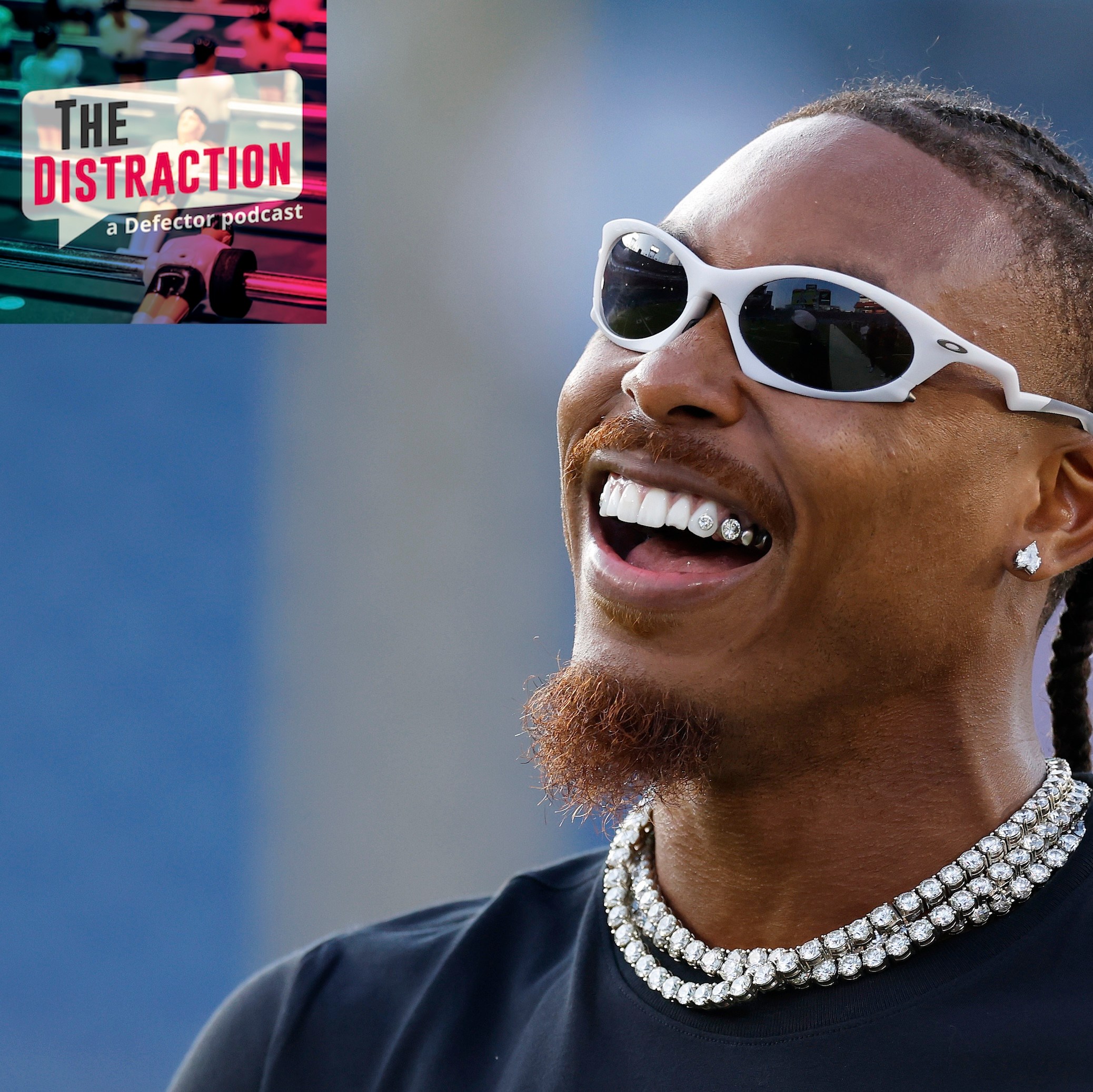 Justin Jefferson wearing sunglasses and looking up and to the left, smiling widely. He's not in uniform. I put the little Defector logo up there so it looks like he's smiling at it.