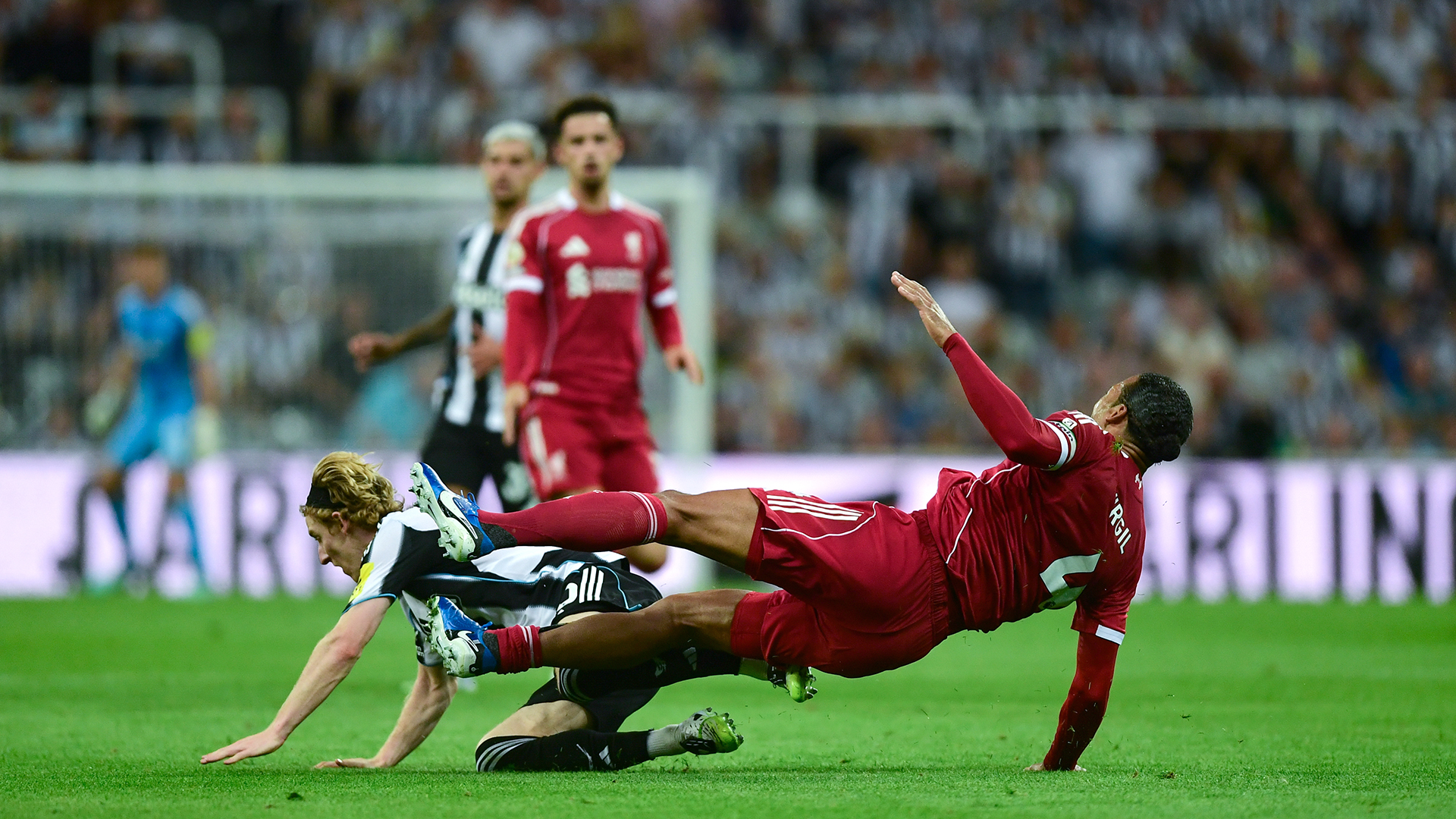 Anthony Gordon of Newcastle United (10) fouls Virgil van Dijk of Liverpool FC (4) during the Premier League match between Newcastle United and Liverpool at St James' Park on August 25, 2025 in Newcastle upon Tyne, England.