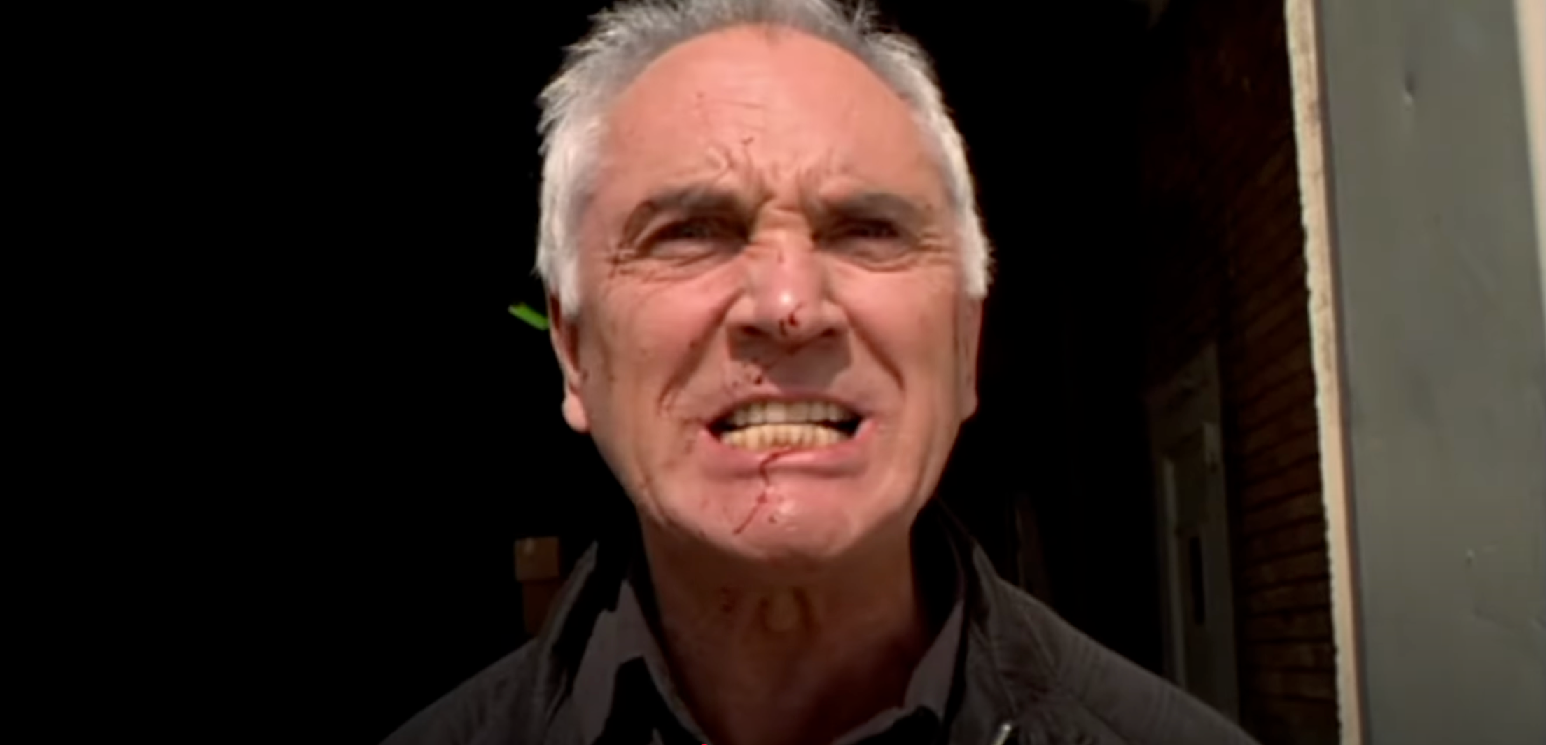 A grimacing Terence Stamp, with some blood splashed across his face, in Stephen Soderbergh's 1999 film "The Limey"