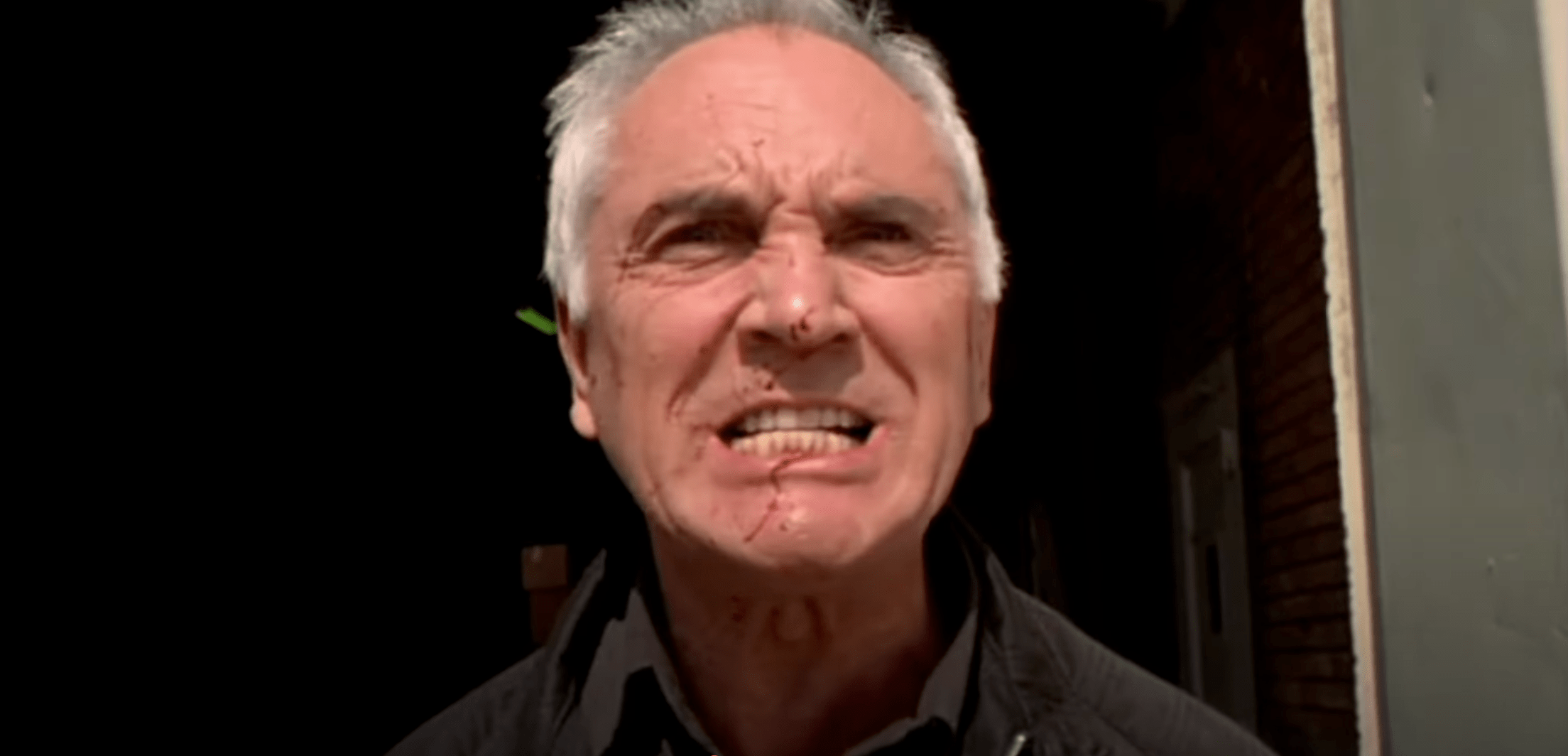 A grimacing Terence Stamp, with some blood splashed across his face, in Stephen Soderbergh's 1999 film "The Limey"