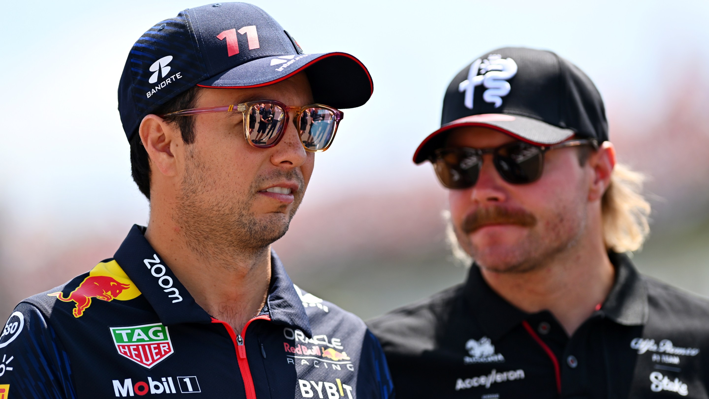 Sergio Perez of Mexico and Oracle Red Bull Racing talks with Valtteri Bottas of Finland and Alfa Romeo F1 on the drivers parade.