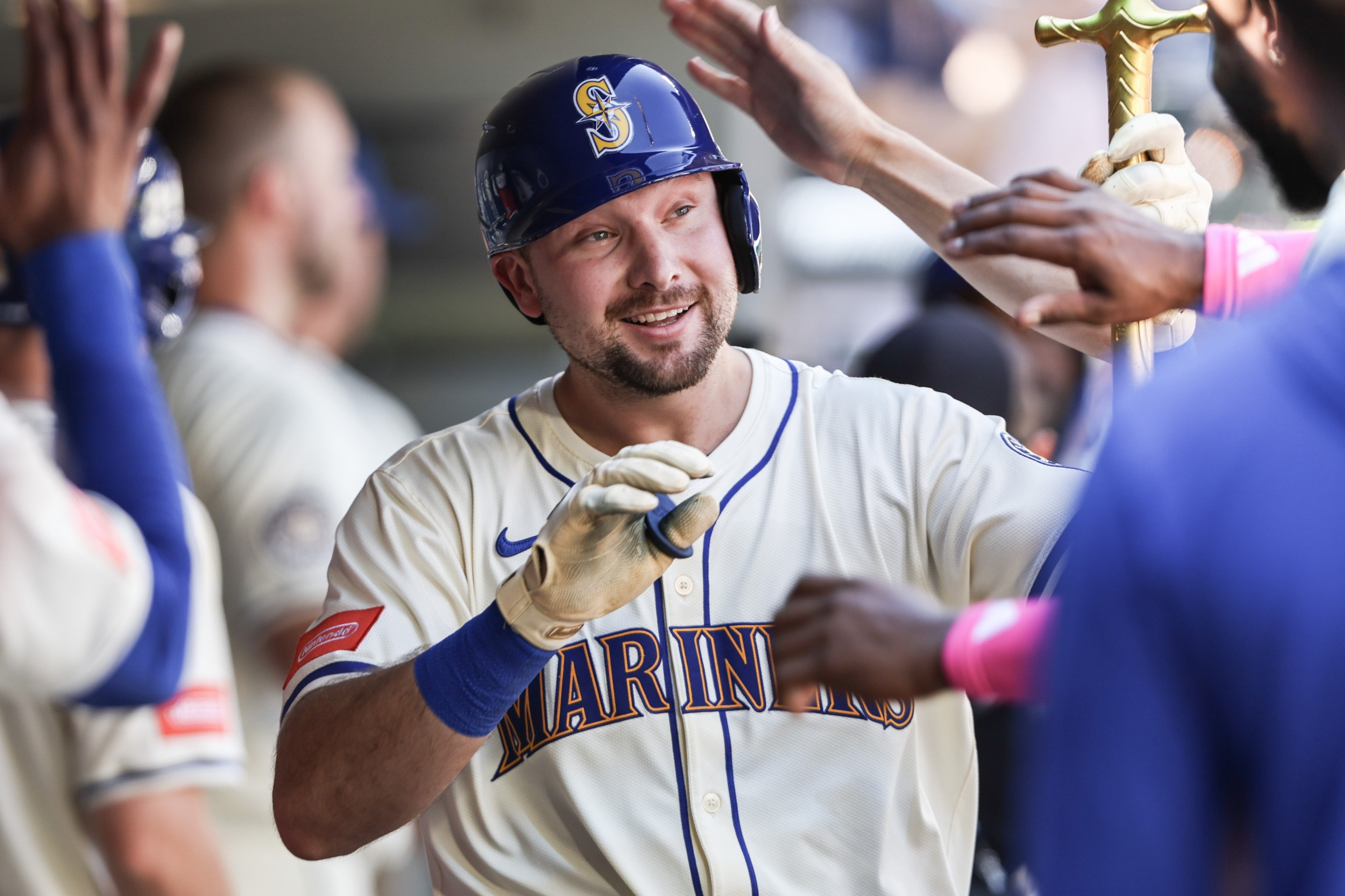 Cal Raleigh #29 of the Seattle Mariners receives high fives in the dugout after hitting his 49th home run of the season setting the record for most home runs during a single season by a catcher.