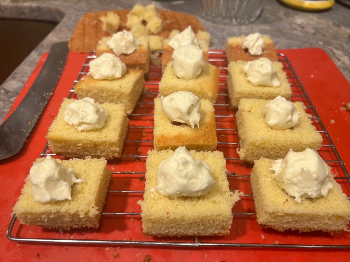 Haphazard blobs of buttercream now sit atop the cubes of sponge.