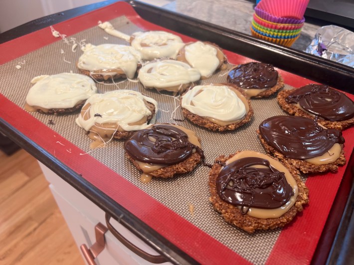 Messy blobs of melted white and dark chocolate sit on the cookies