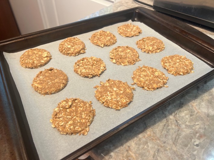Raw circles of cookie dough on a parchment-lined baking sheet