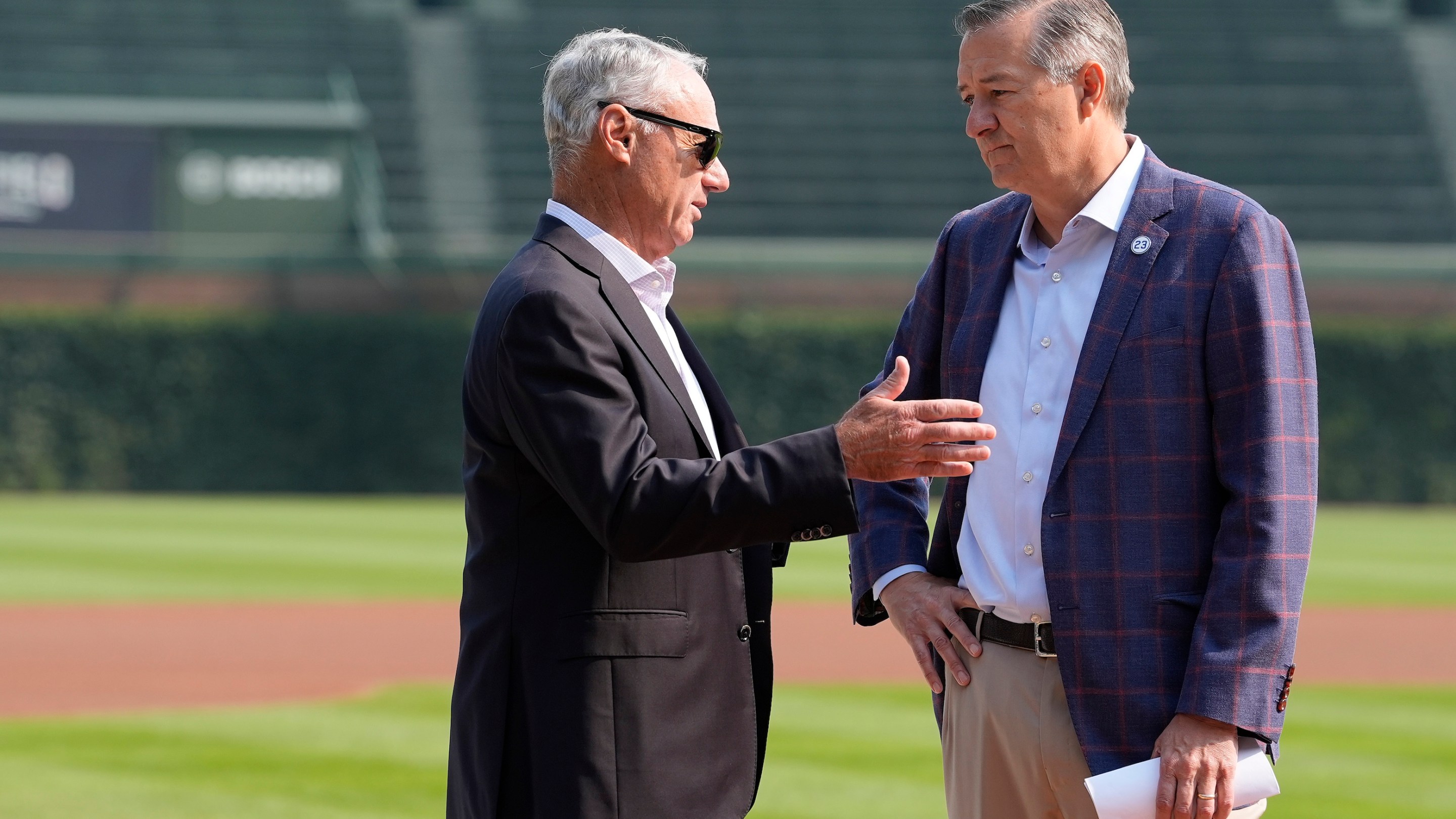 Major League Baseball Commissioner Rob Manfred (L) speaks with owner Tom Ricketts of the Chicago Cubs during the 2027 Chicago All-Star Game Announcement before a game between the Baltimore Orioles and Chicago Cubs at Wrigley Field. Manfred's got shades on.