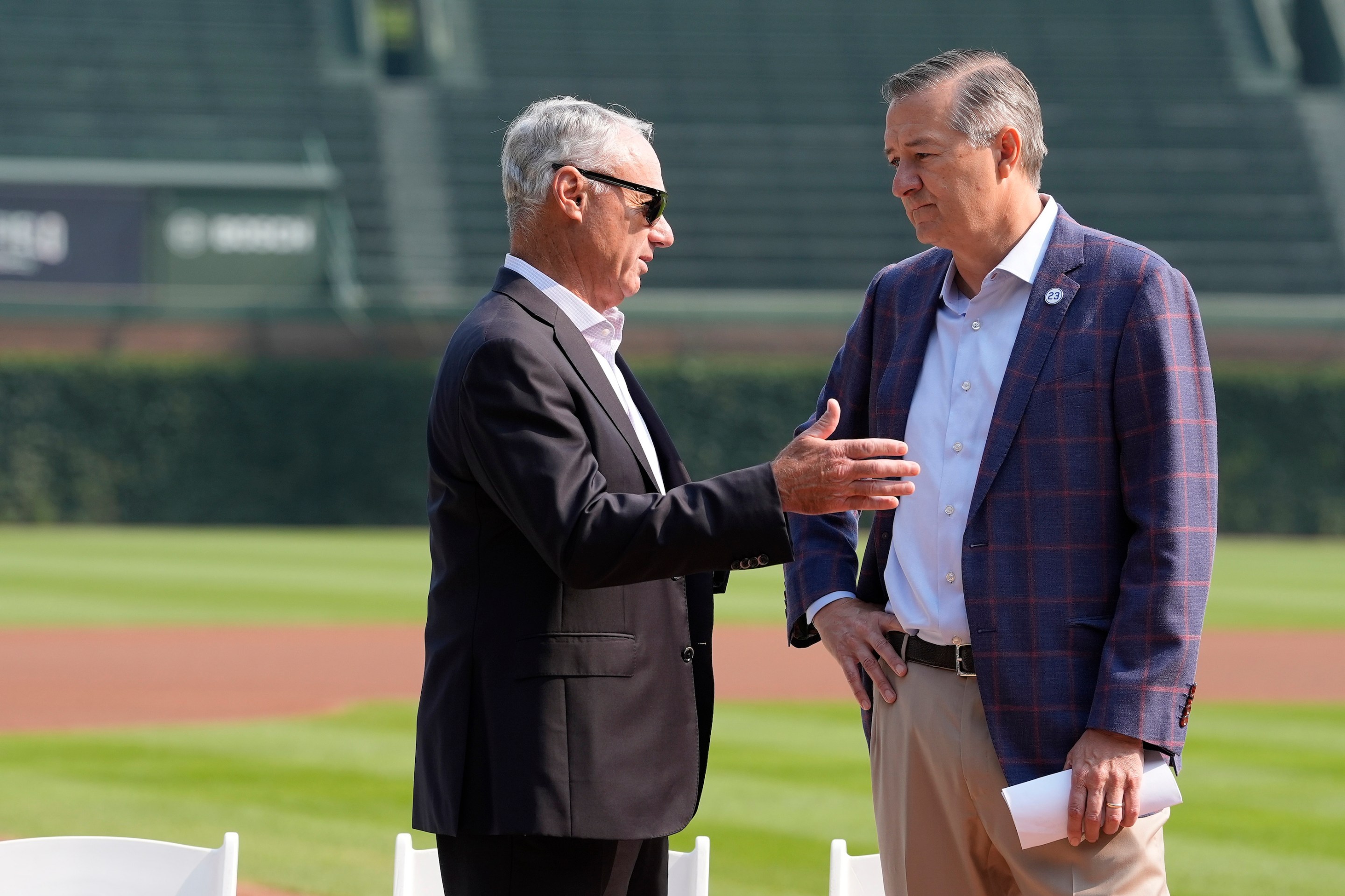 Major League Baseball Commissioner Rob Manfred (L) speaks with owner Tom Ricketts of the Chicago Cubs during the 2027 Chicago All-Star Game Announcement before a game between the Baltimore Orioles and Chicago Cubs at Wrigley Field. Manfred's got shades on.