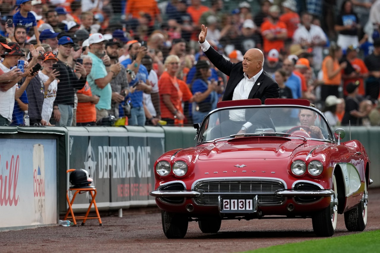 Cal Ripken Jr. waves to fans as he rides around the warning track