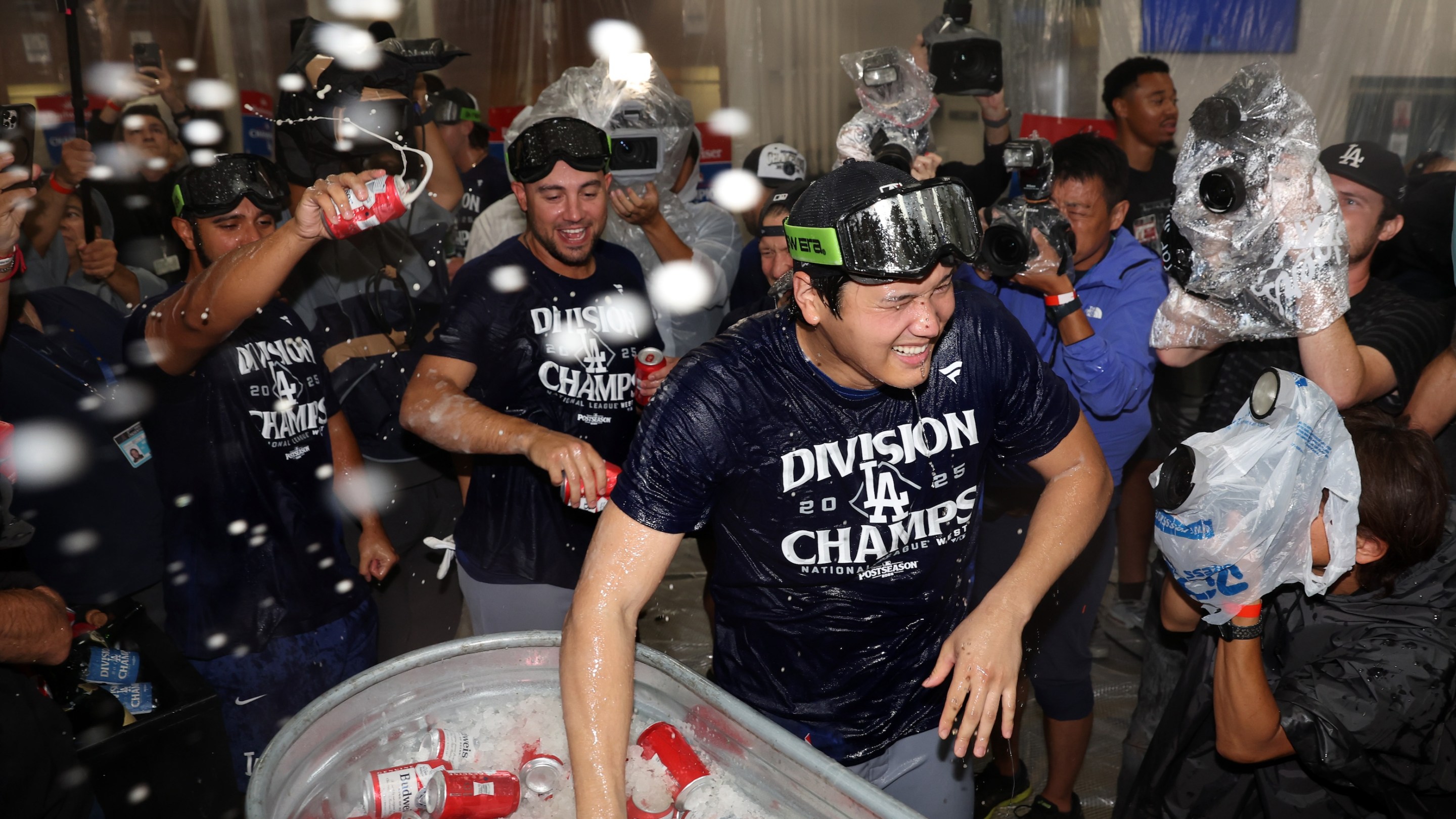 Shohei Ohtani of the Los Angeles Dodgers celebrates with teammates in the locker room after defeating the Arizona Diamondbacks 8-0 to clinch the National League West title.