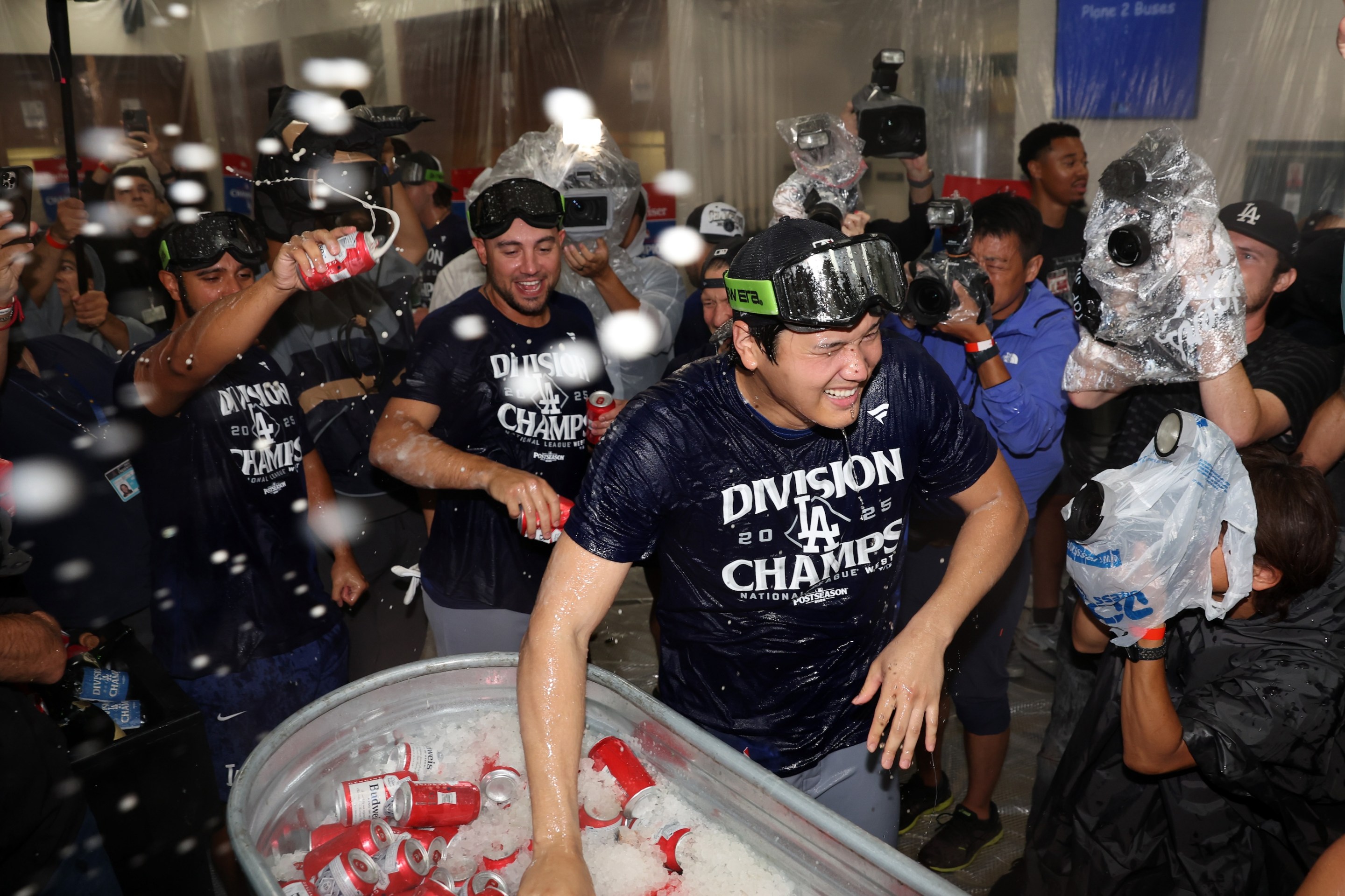 Shohei Ohtani of the Los Angeles Dodgers celebrates with teammates in the locker room after defeating the Arizona Diamondbacks 8-0 to clinch the National League West title.