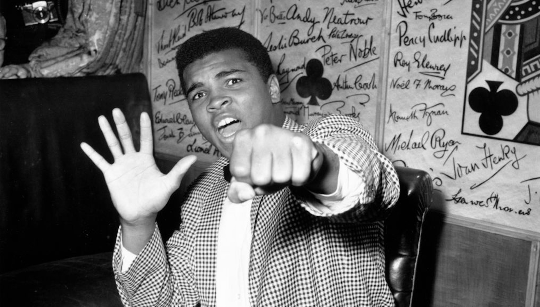 27th May 1963: Supremely confident American boxer Cassius Clay holds up five fingers in a prediction of how many rounds it will take him to knock out British boxer Henry Cooper.