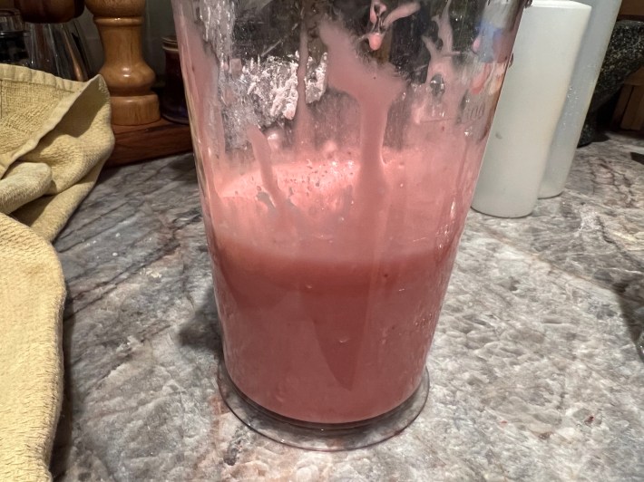 Pink strawberry icing in a pitcher.