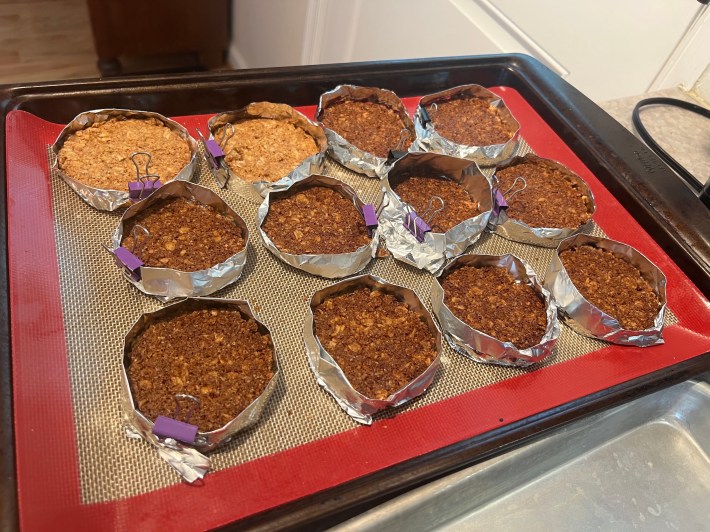 Twelve baked cookies with stupid foil rings around them, held together by binder clips