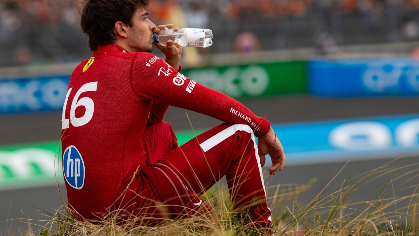 Charles Leclerc of Monaco and Ferrari sits on the embankment.