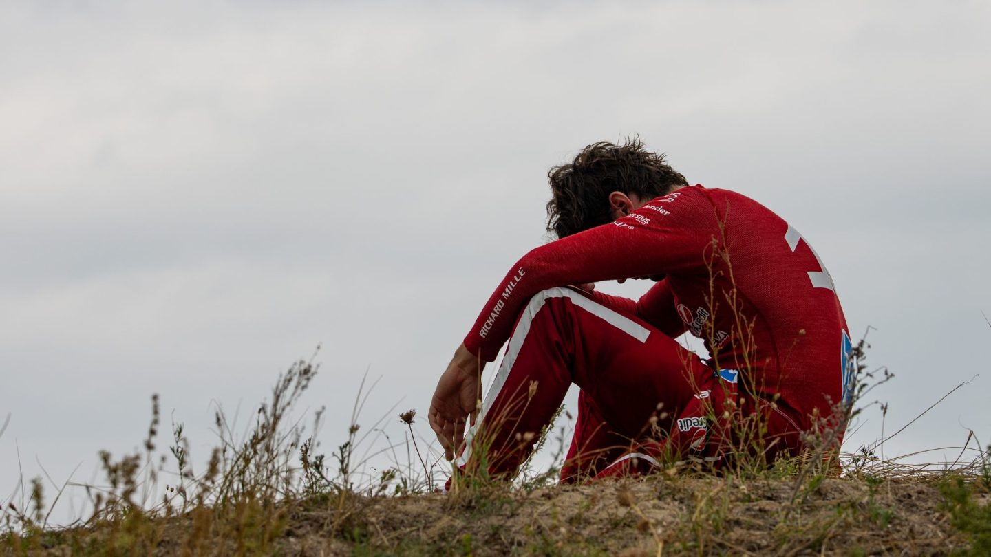 Charles Leclerc of Monaco and Ferrari sits on the embankment following his crash.