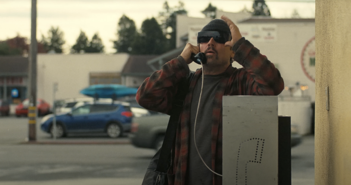 Leonardo DiCaprio's character talks into a payphone, from the movie One Battle After Another.