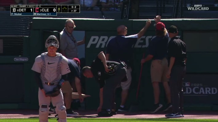 A bunch of stadium staffers trying to clean up the mess from when Angel Martinez's foul ball obliterated a camera behind home plate.
