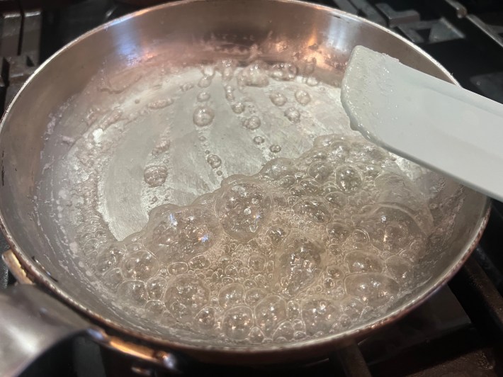 Sugar and water bubble in a pan.