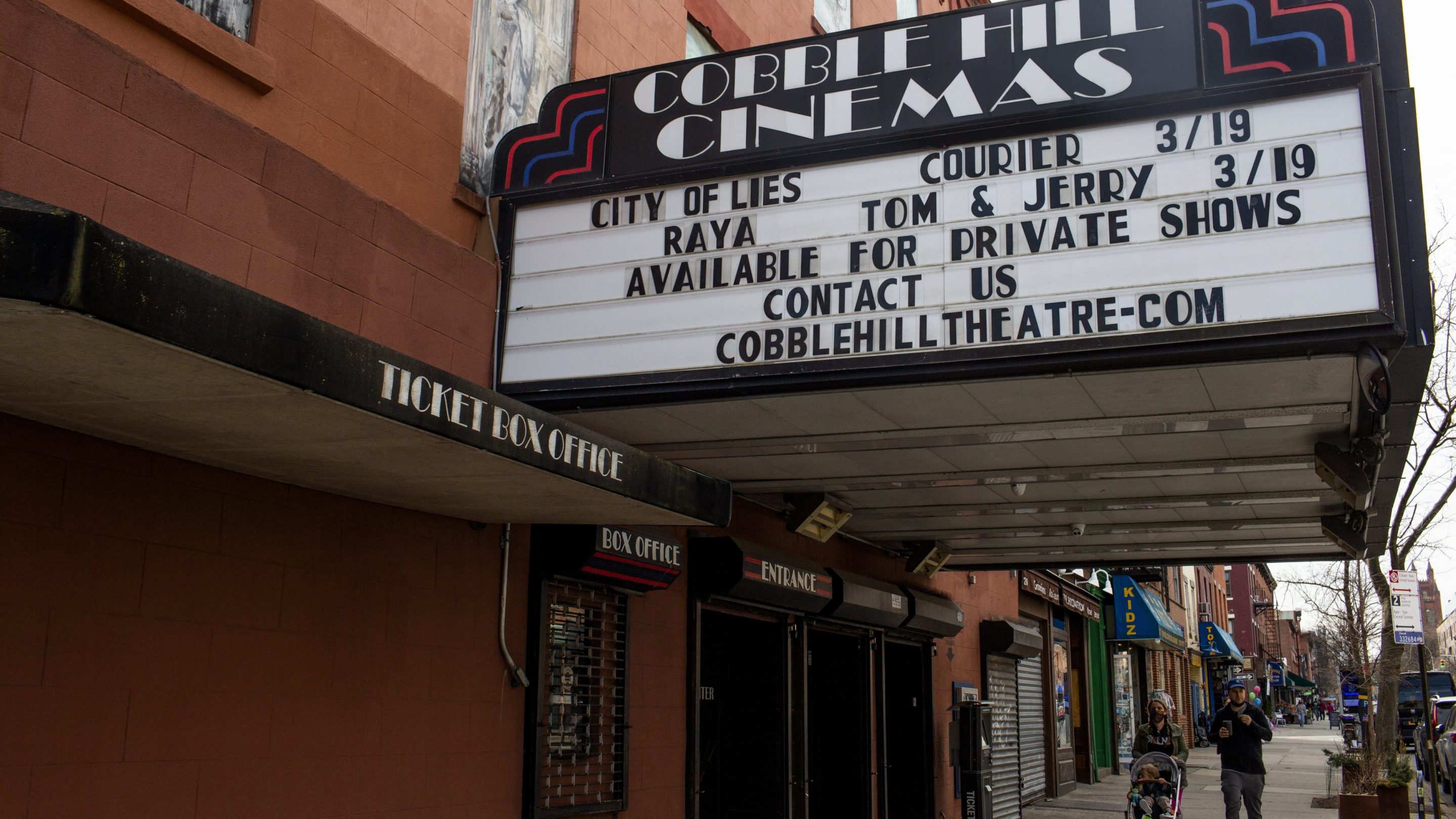 A movie theater, closed for a year because of the COVID-19 pandemic, advertises its reopening on March 12, 2021, in the Cobble Hill neighborhood of Brooklyn, New York