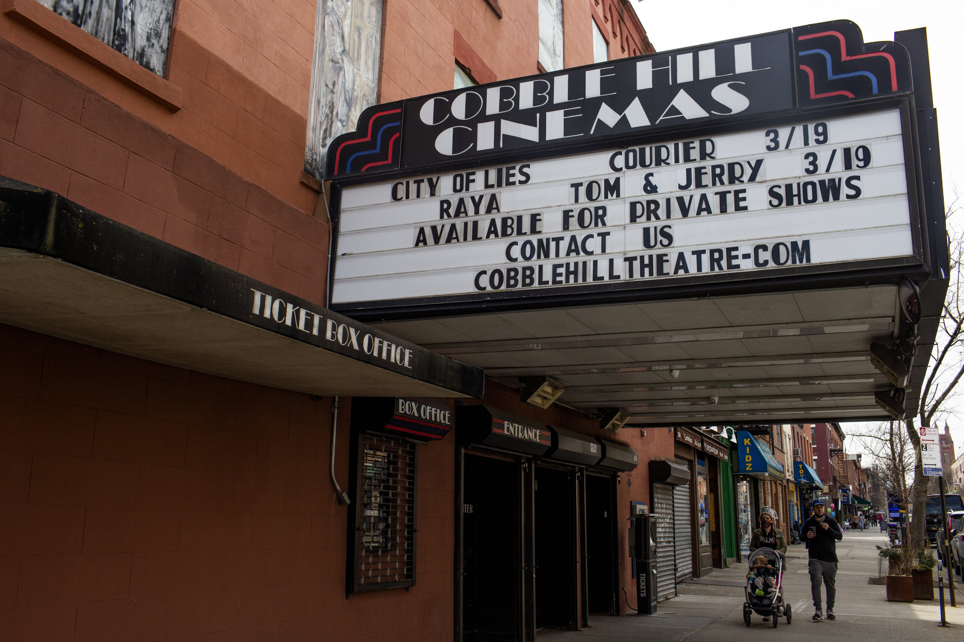 A movie theater, closed for a year because of the COVID-19 pandemic, advertises its reopening on March 12, 2021, in the Cobble Hill neighborhood of Brooklyn, New York