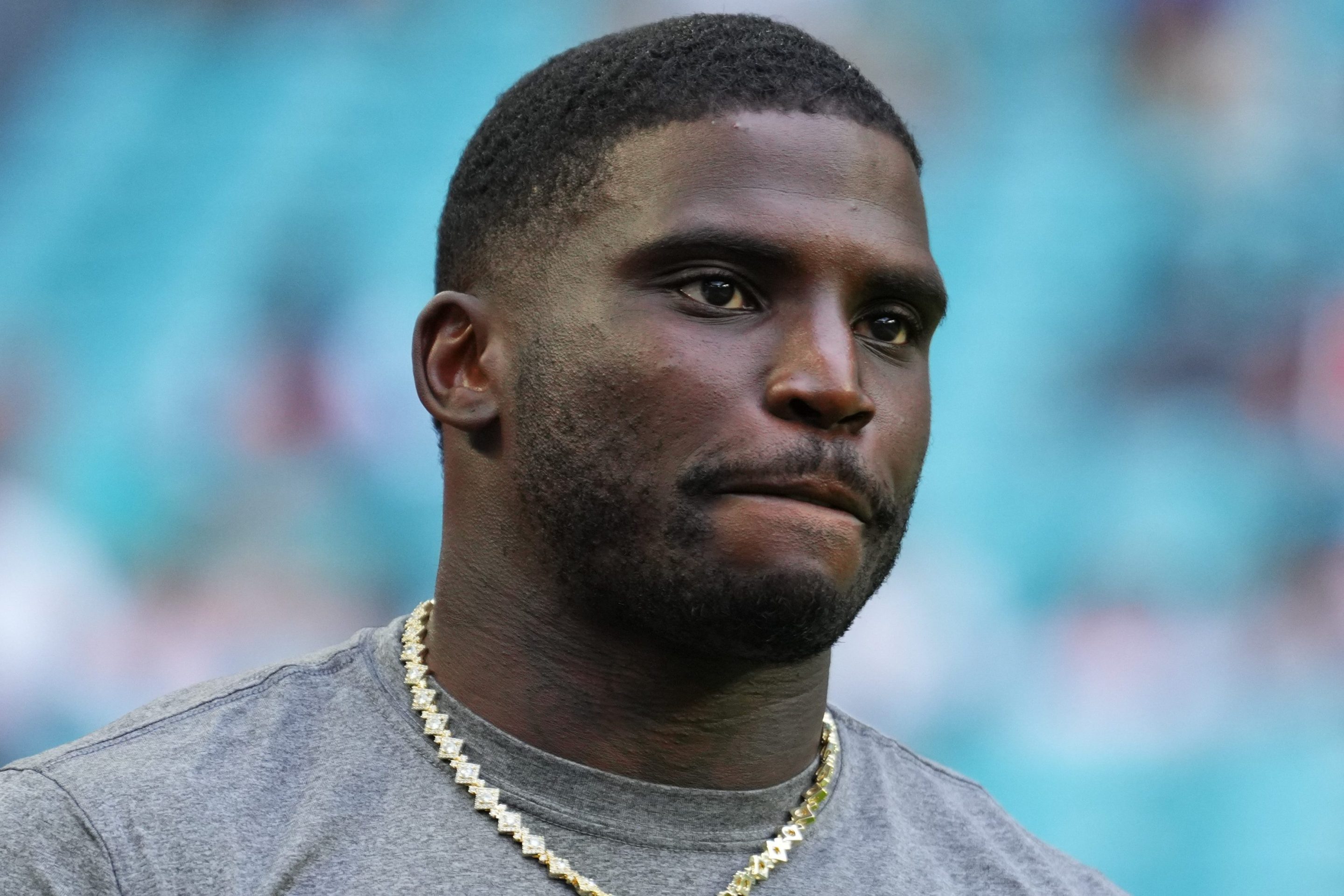 Tyreek Hill #10 of the Miami Dolphins looks on prior to a NFL Preseason 2025 game between Jacksonville Jaguars and Miami Dolphins at Hard Rock Stadium on August 23, 2025 in Miami Gardens, Florida. He is wearing a grey shirt with the Dolphins logo.