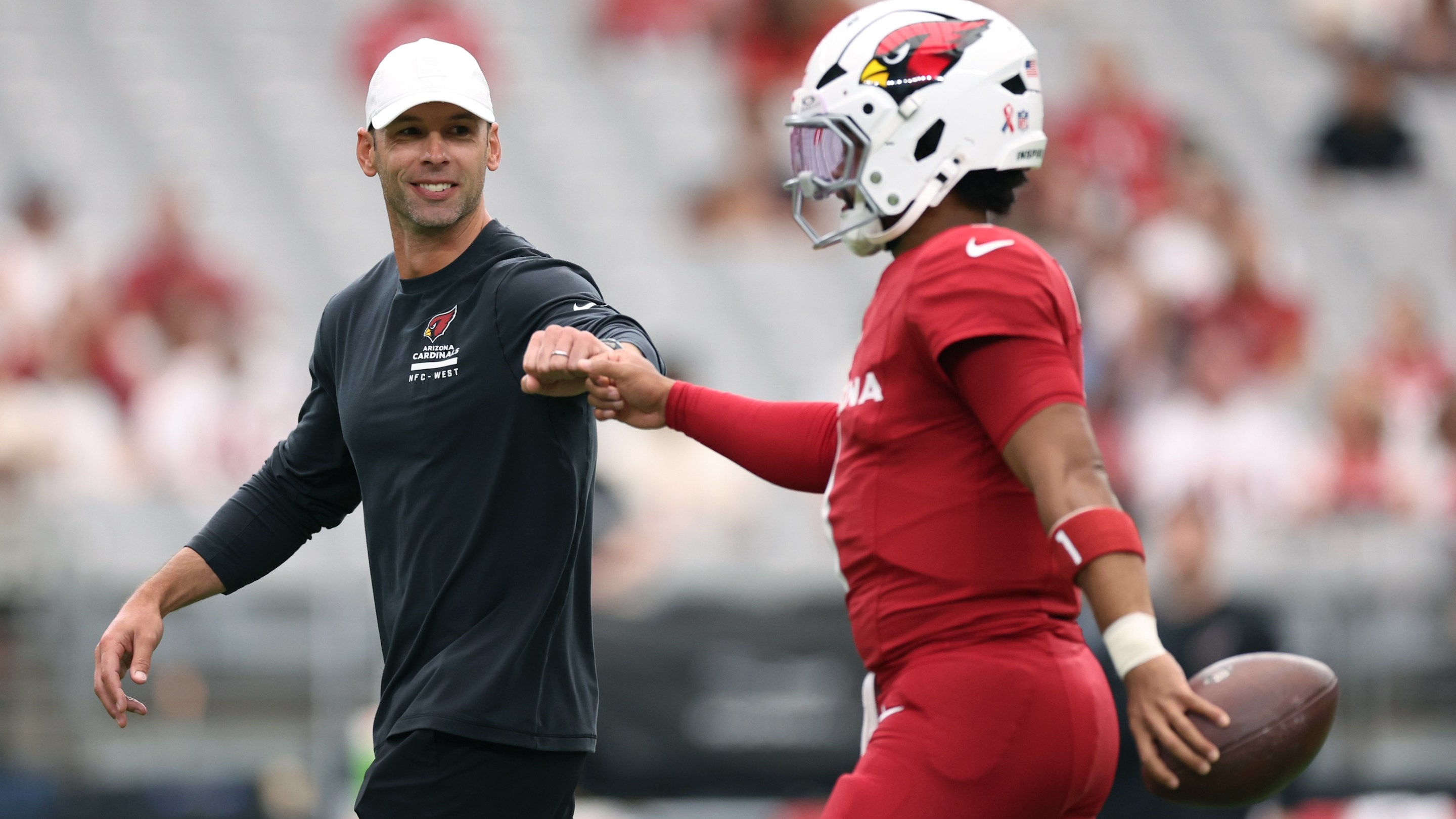 Head coach Jonathan Gannon fist bumps Kyler Murray #1 of the Arizona Cardinals prior to a game against the Carolina Panthers at State Farm Stadium on September 14, 2025 in Glendale, Arizona.
