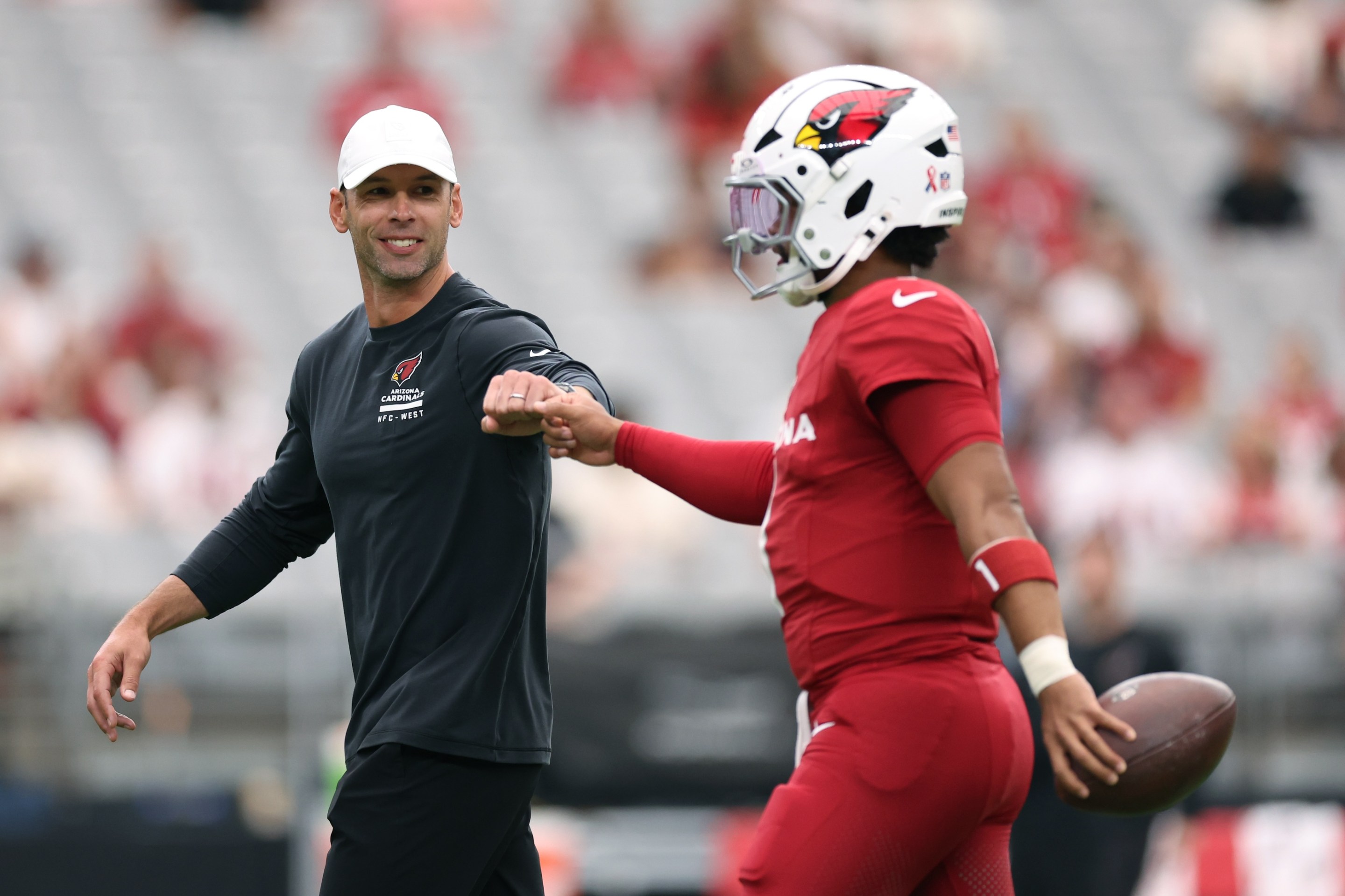 Head coach Jonathan Gannon fist bumps Kyler Murray #1 of the Arizona Cardinals prior to a game against the Carolina Panthers at State Farm Stadium on September 14, 2025 in Glendale, Arizona.