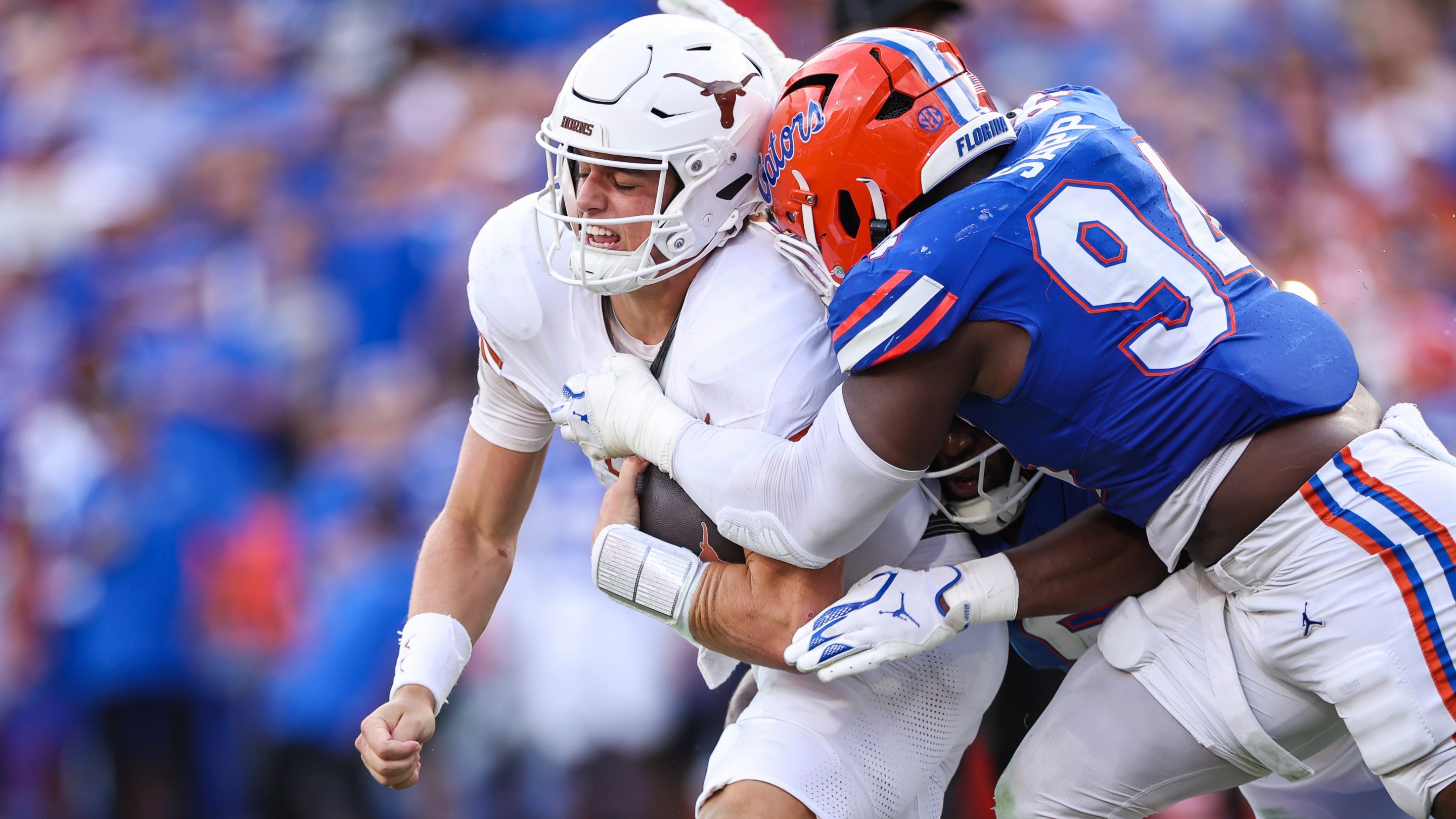 A Florida Gator tackles a Texas Longhorn in a college football game.