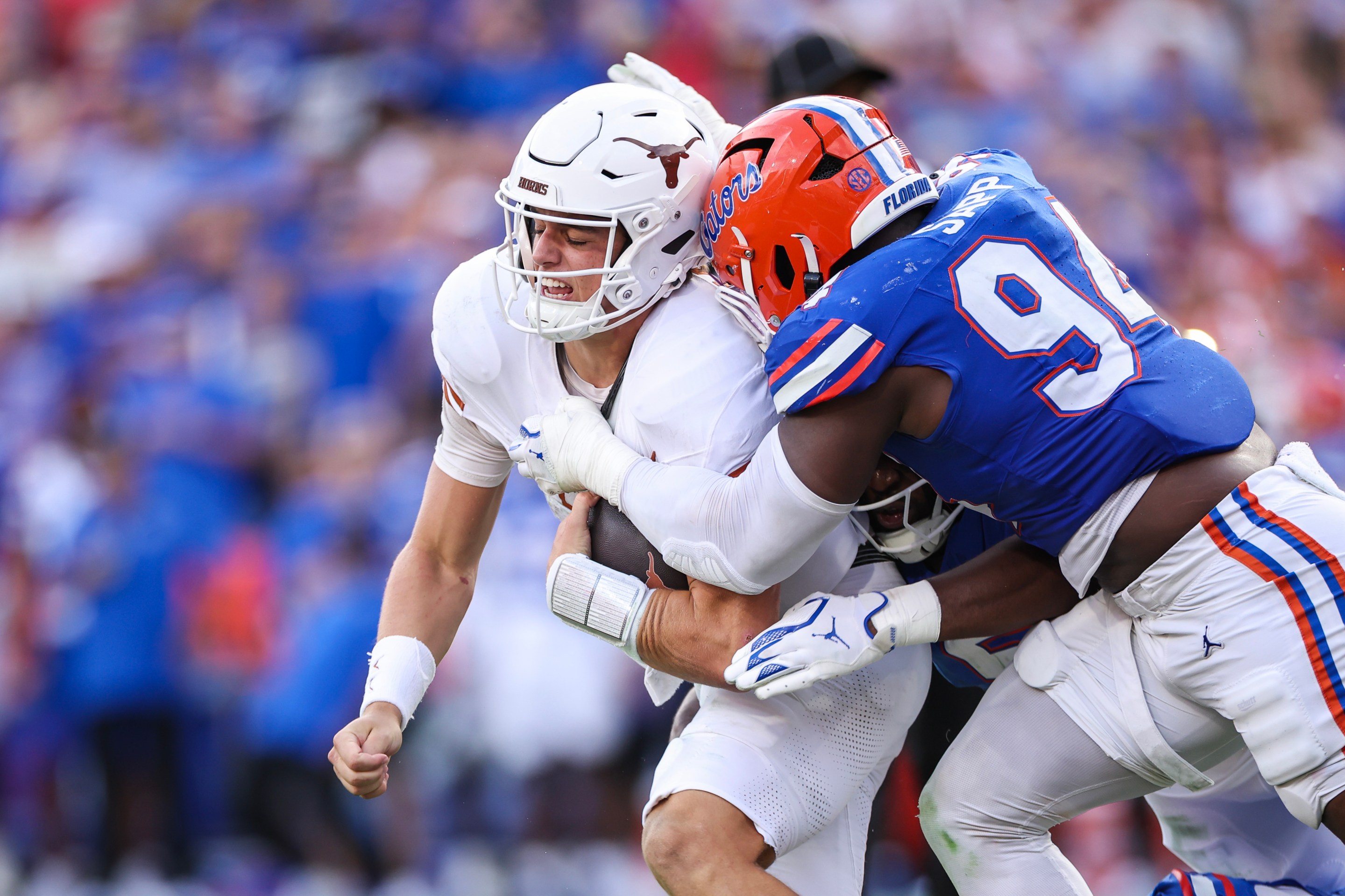 A Florida Gator tackles a Texas Longhorn in a college football game.