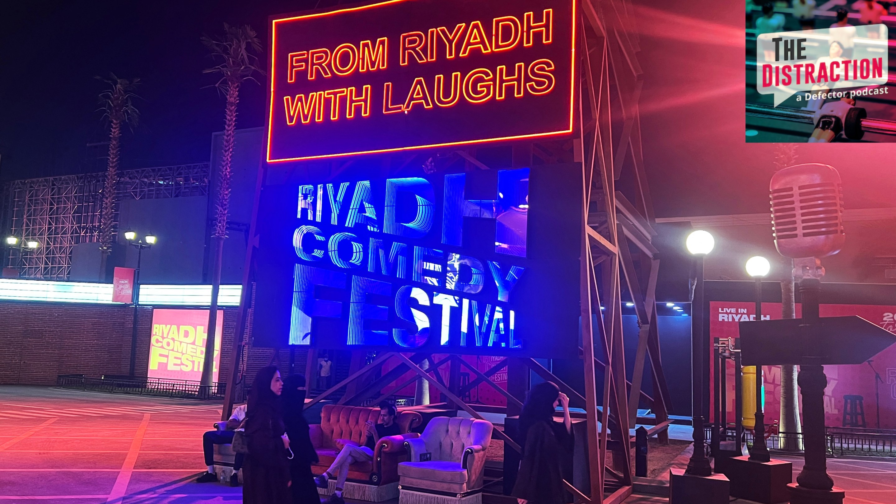 People walk past an installation showcasing the Riyadh Comedy Festival at Boulevard City in the Hittin neighborhood of Riyadh on October 6, 2025. The Distraction logo is at upper right.