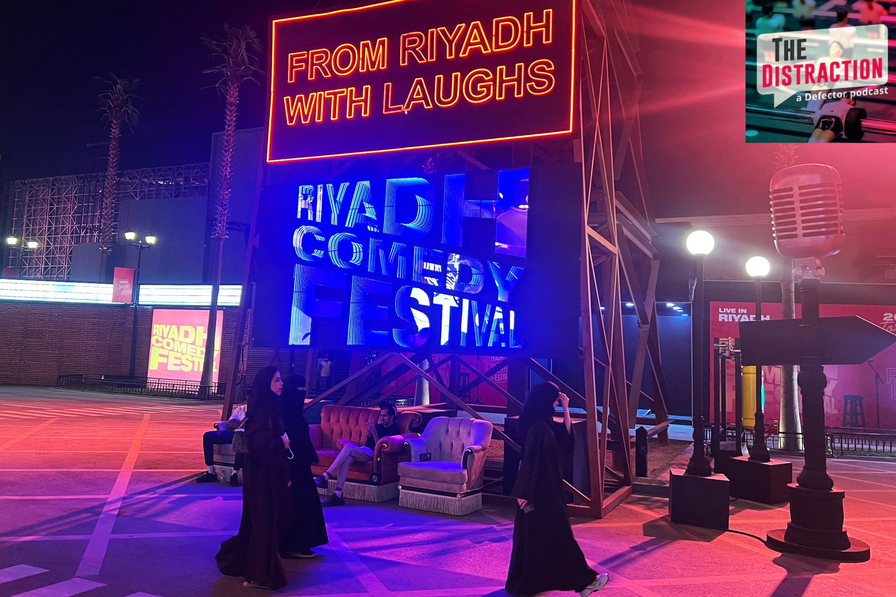 People walk past an installation showcasing the Riyadh Comedy Festival at Boulevard City in the Hittin neighborhood of Riyadh on October 6, 2025. The Distraction logo is at upper right.