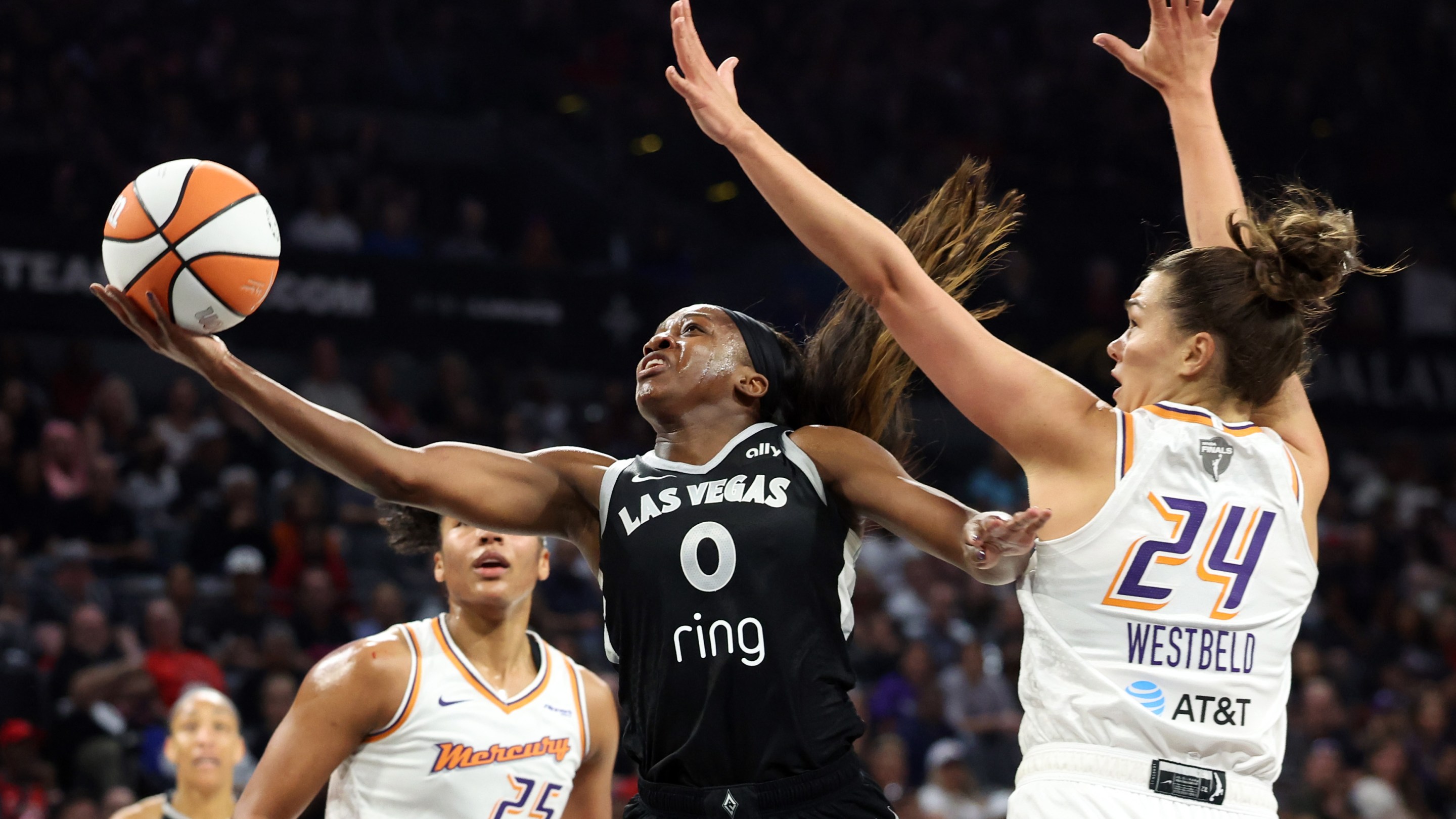 LAS VEGAS, NEVADA - OCTOBER 05: Jackie Young #0 of the Las Vegas Aces shoots the ball between Alyssa Thomas #25 and Kathryn Westbeld #24 of the Phoenix Mercury in the first quarter of Game Two of the 2025 WNBA Playoffs finals at Michelob ULTRA Arena on October 05, 2025 in Las Vegas, Nevada.