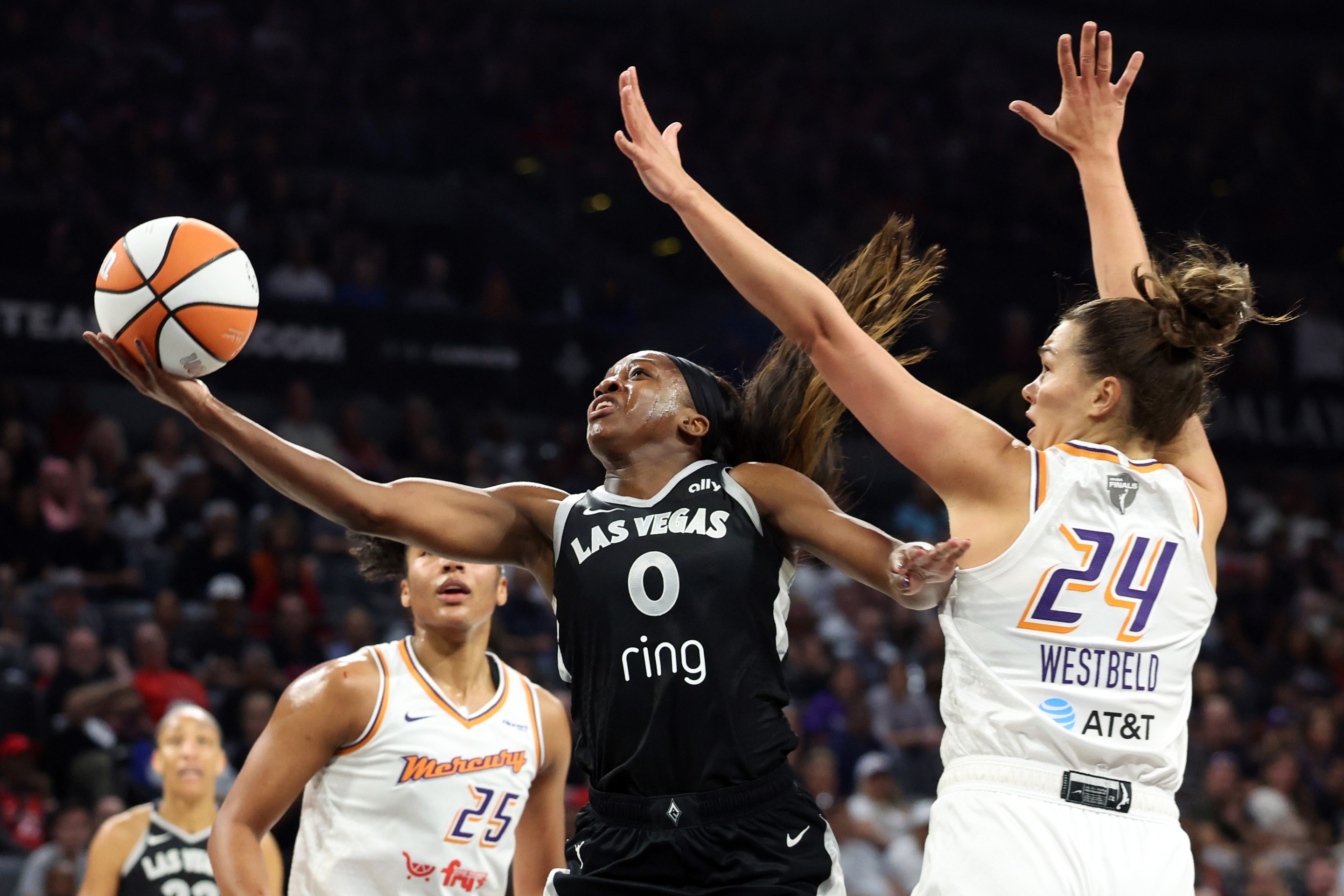 LAS VEGAS, NEVADA - OCTOBER 05: Jackie Young #0 of the Las Vegas Aces shoots the ball between Alyssa Thomas #25 and Kathryn Westbeld #24 of the Phoenix Mercury in the first quarter of Game Two of the 2025 WNBA Playoffs finals at Michelob ULTRA Arena on October 05, 2025 in Las Vegas, Nevada.