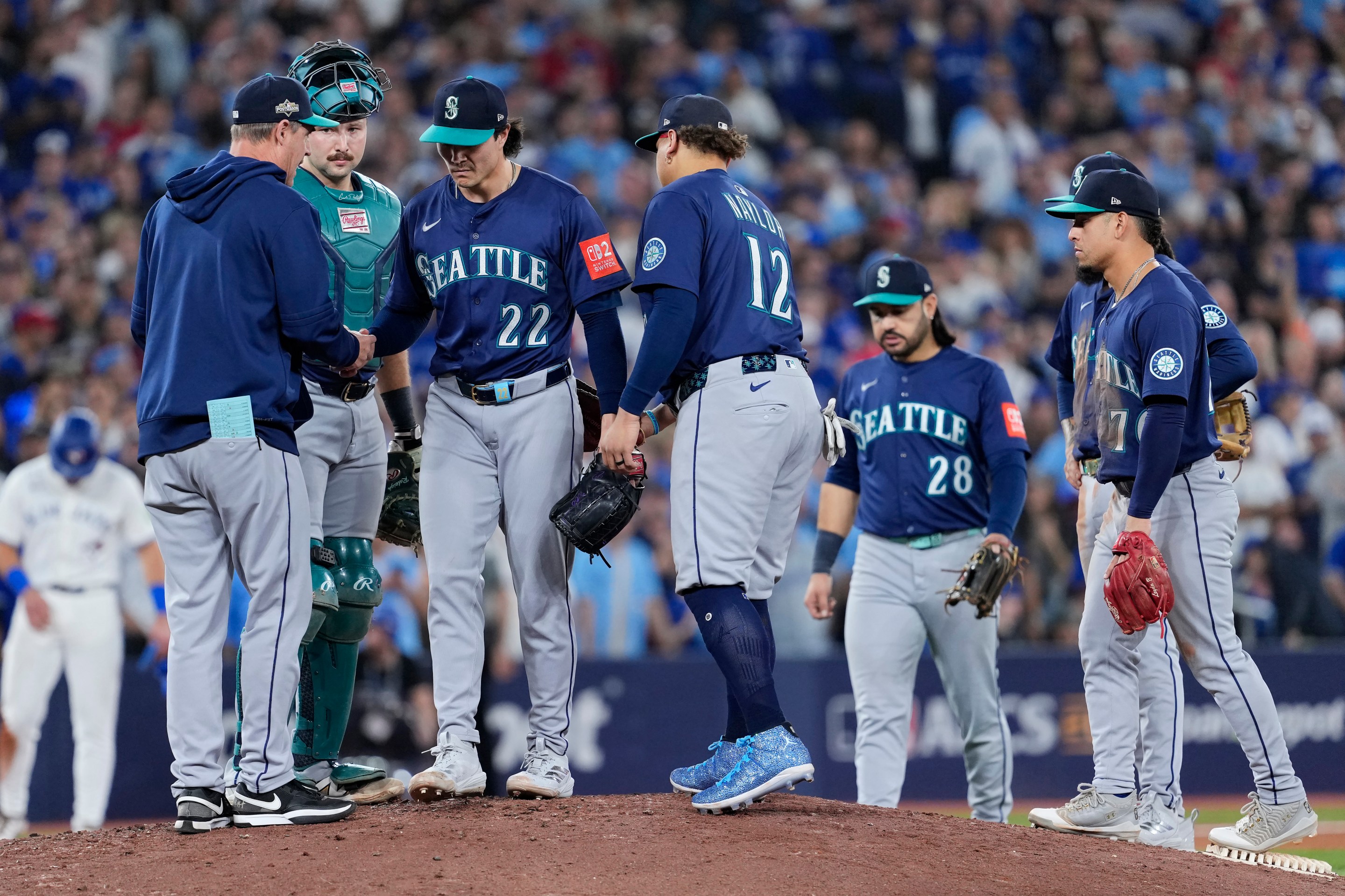 TORONTO, ONTARIO - OCTOBER 20: Manager Dan Wilson #6 of the Seattle Mariners takes the ball from Bryan Woo #22 during a pitching change in the seventh inning against the Toronto Blue Jays in game seven of the American League Championship Series at the Rogers Centre on October 20, 2025 in Toronto, Ontario.
