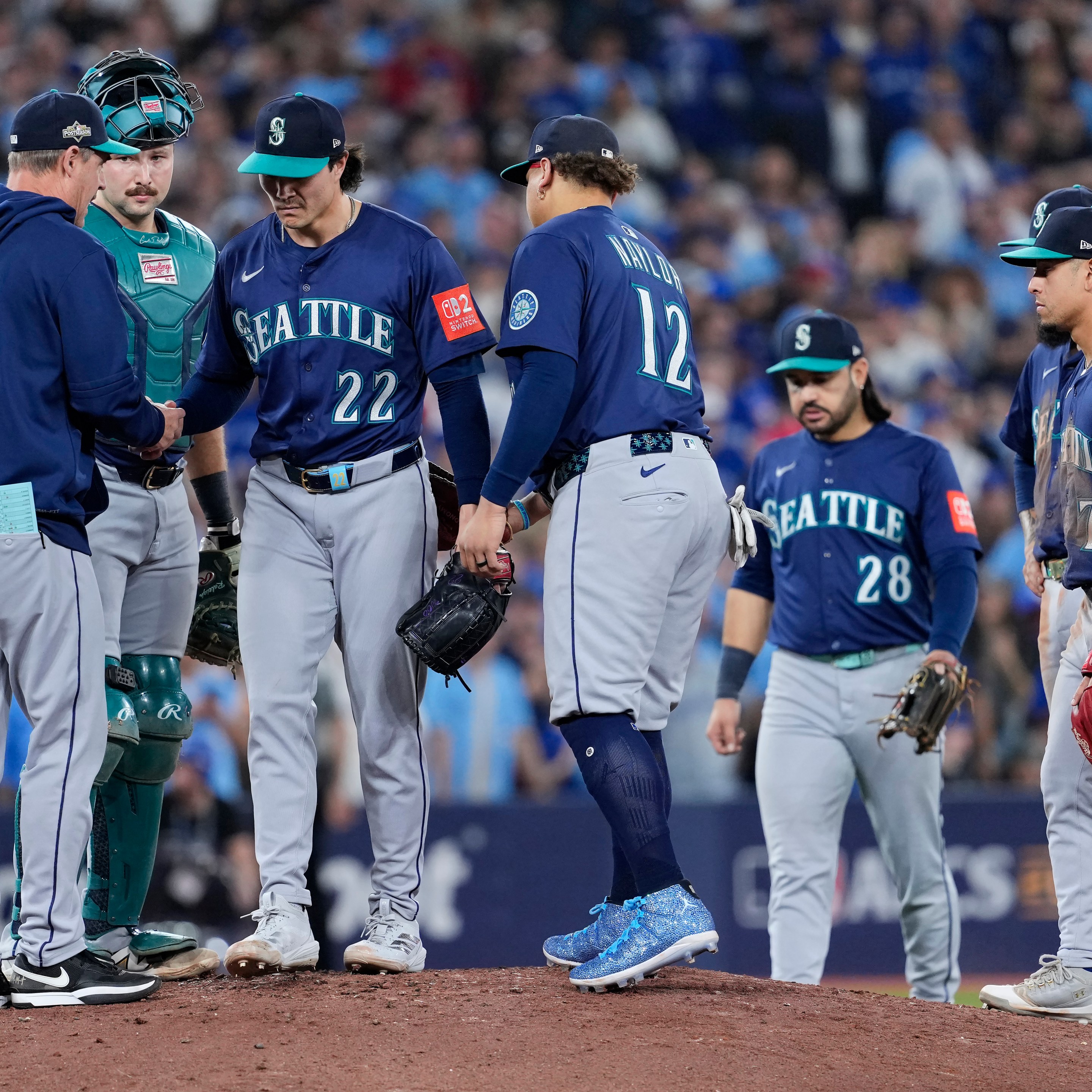 TORONTO, ONTARIO - OCTOBER 20: Manager Dan Wilson #6 of the Seattle Mariners takes the ball from Bryan Woo #22 during a pitching change in the seventh inning against the Toronto Blue Jays in game seven of the American League Championship Series at the Rogers Centre on October 20, 2025 in Toronto, Ontario.