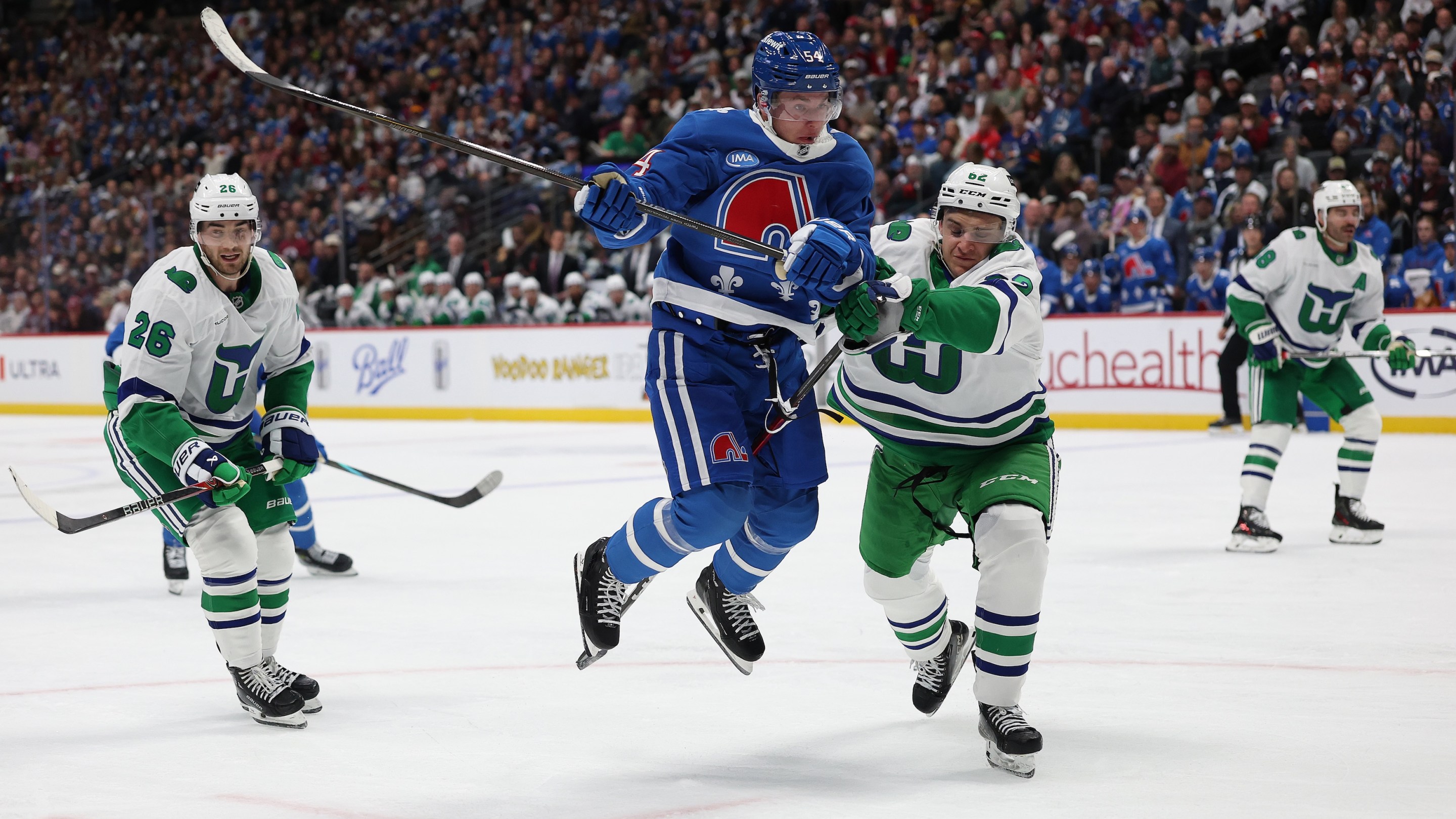 DENVER, COLORADO - OCTOBER 23: Gavin Brindley #54 of the Colorado Avalanche fights for the puck against Charles-Alexis Legault #62 of the Carolina Hurricanes in the second period at Ball Arena on October 23, 2025 in Denver, Colorado. (Photo by Matthew Stockman/Getty Images)