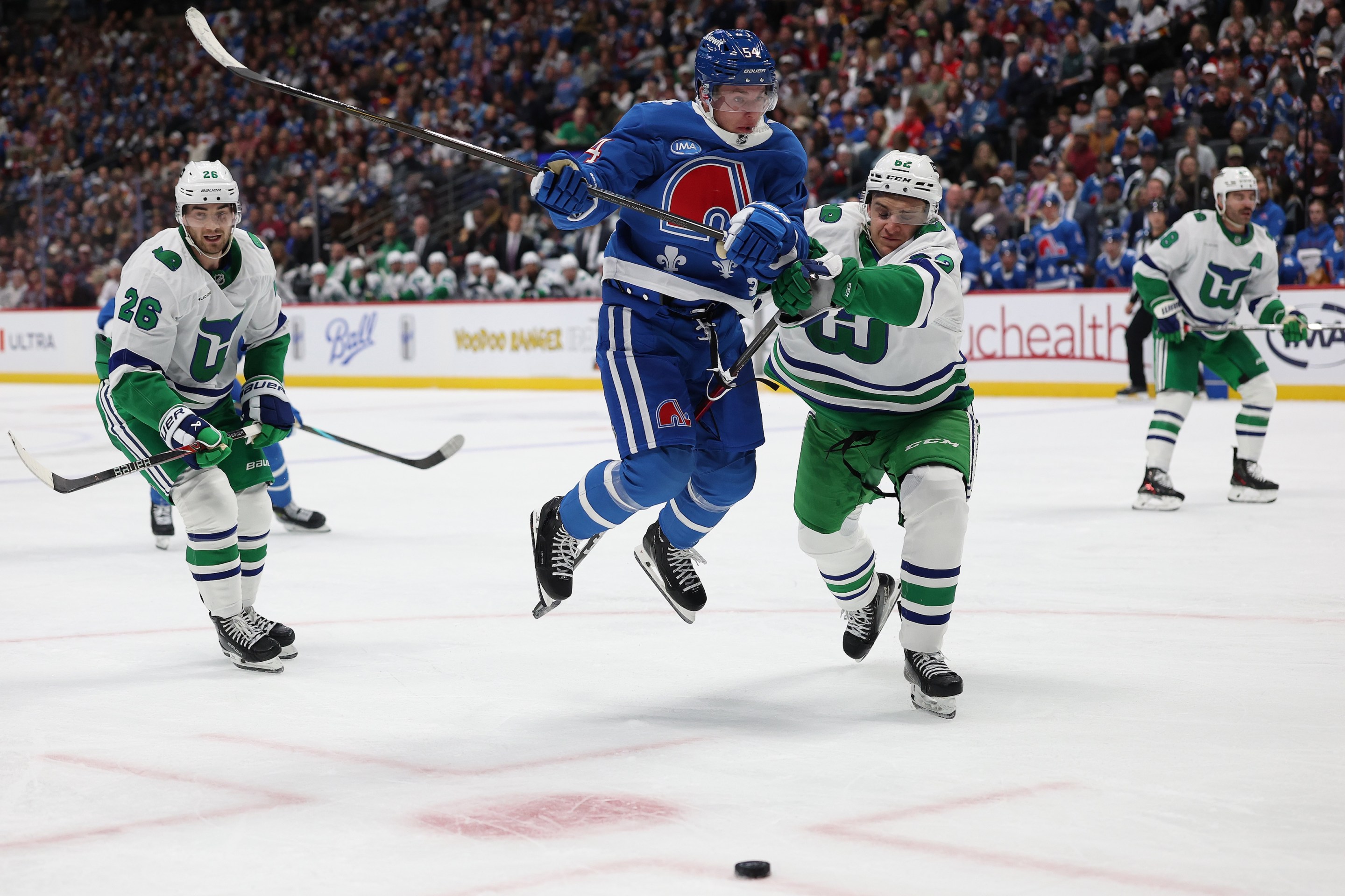 DENVER, COLORADO - OCTOBER 23: Gavin Brindley #54 of the Colorado Avalanche fights for the puck against Charles-Alexis Legault #62 of the Carolina Hurricanes in the second period at Ball Arena on October 23, 2025 in Denver, Colorado. (Photo by Matthew Stockman/Getty Images)