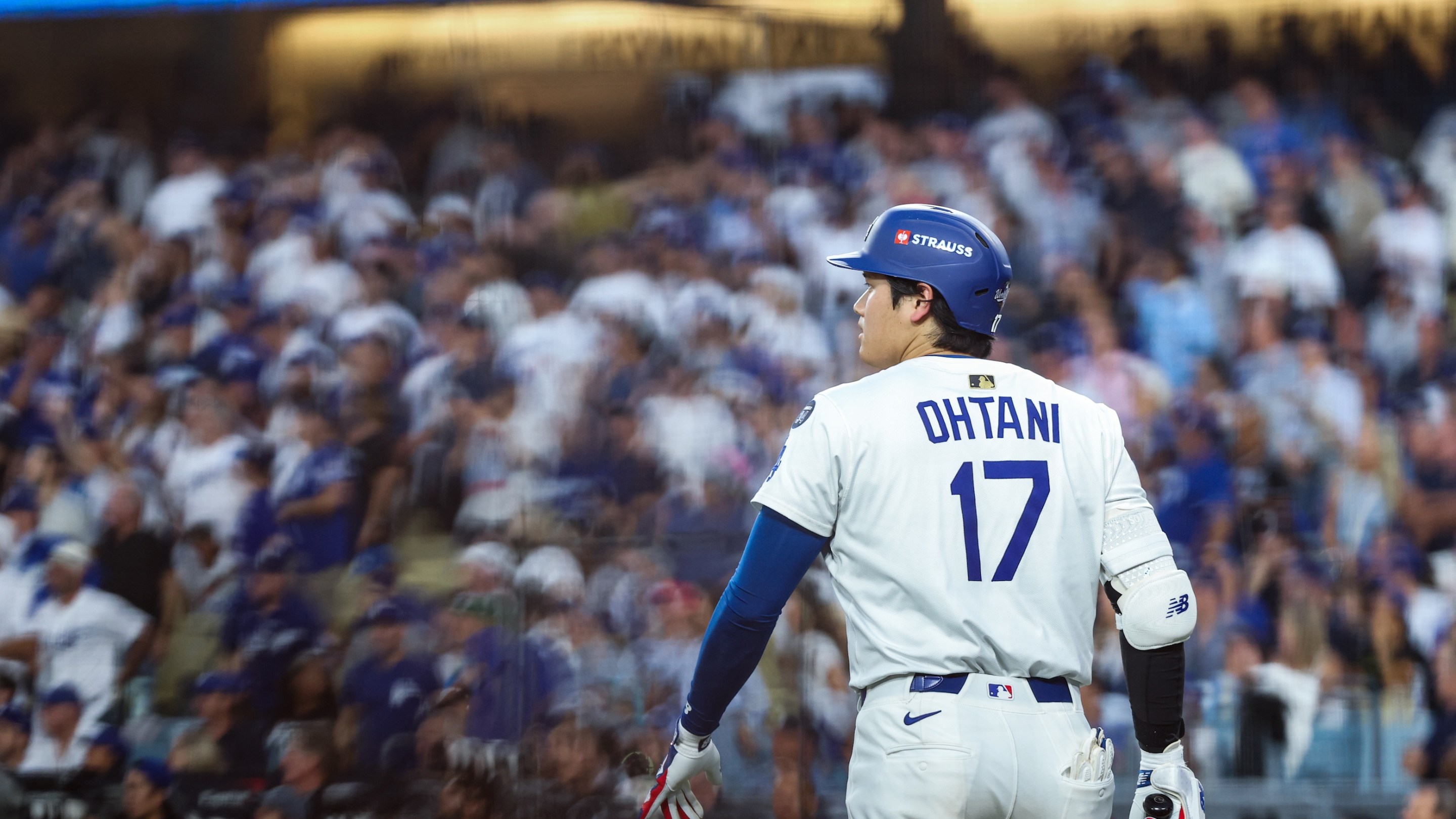 Shohei Ohtani of the Los Angeles Dodgers looks on during Game Five of the 2025 World Series. The background of the fans in the seats is indistinct, but Ohtani is in focus.