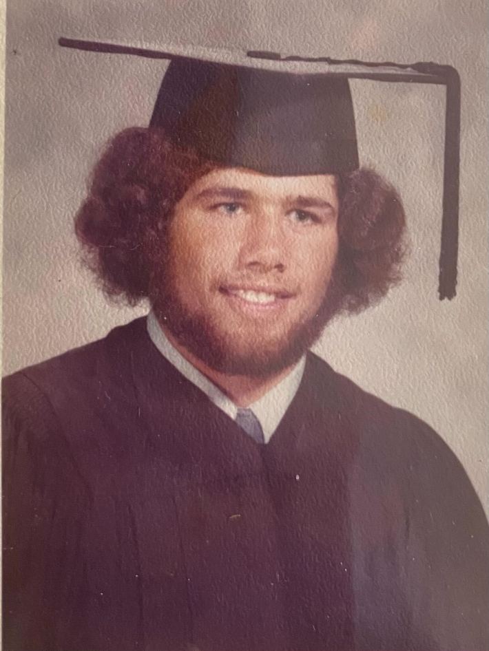 A photo of Mike Lucido in a graduation cap and gown.